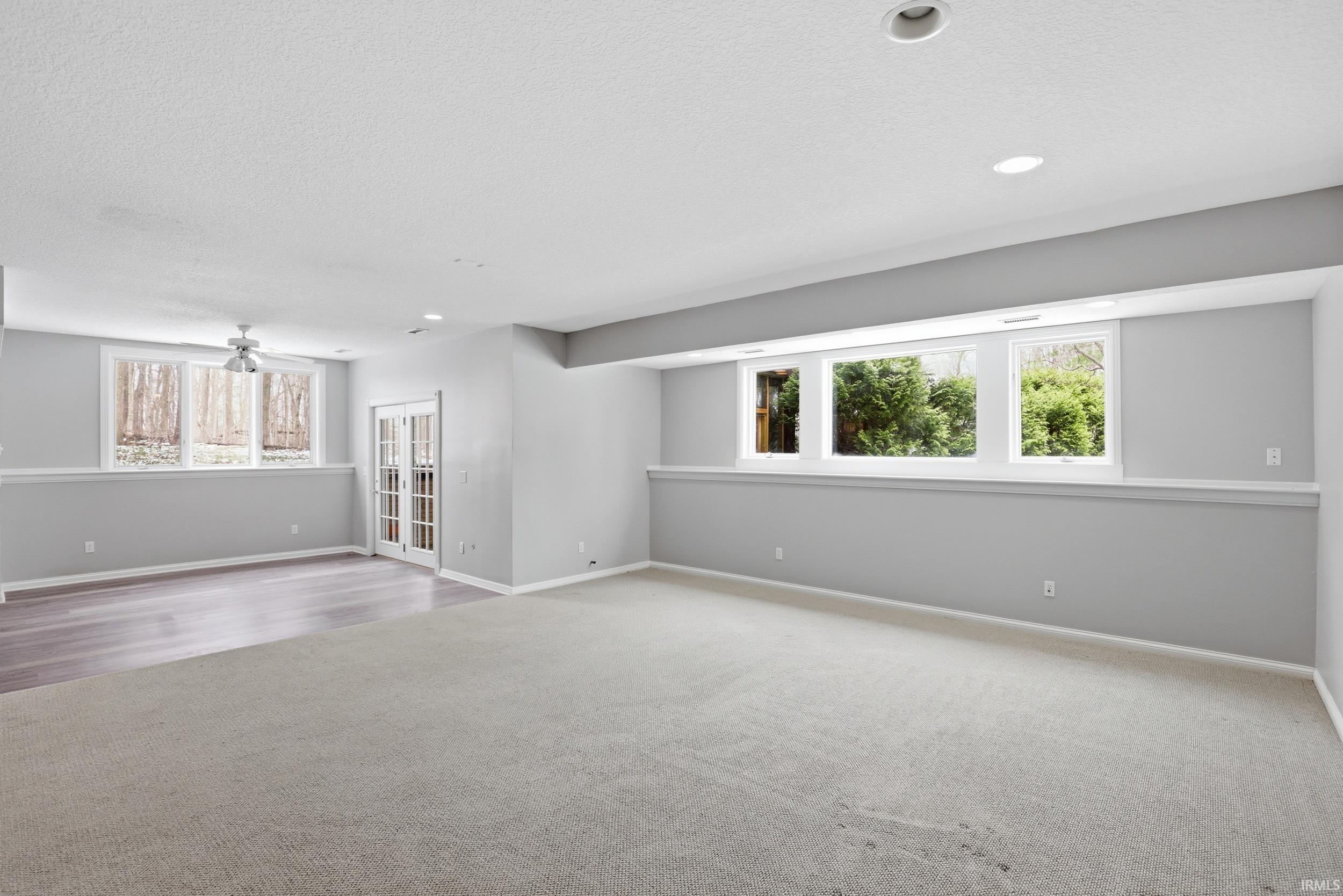 Carpeted empty room featuring ceiling fan, a textured ceiling, and recessed lighting