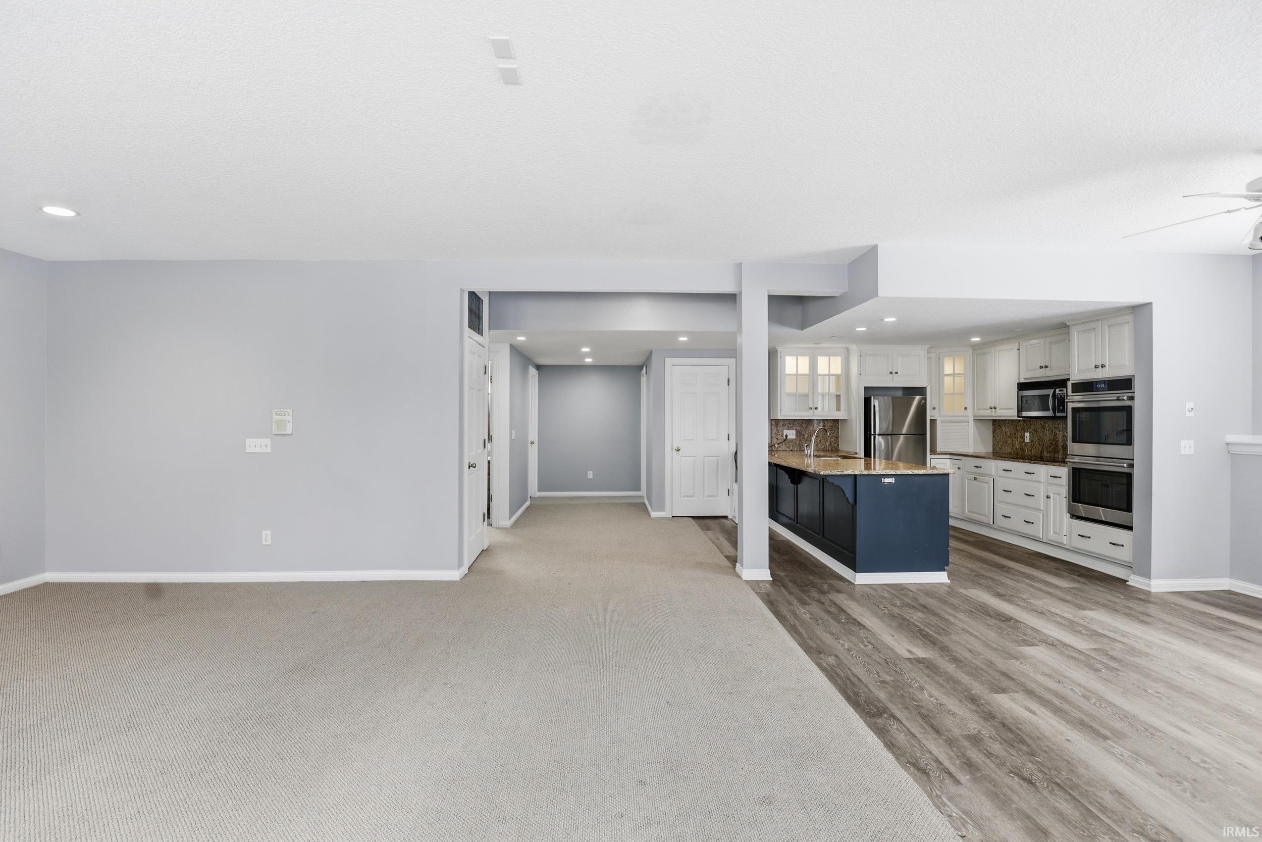 Unfurnished living room with a ceiling fan and recessed lighting