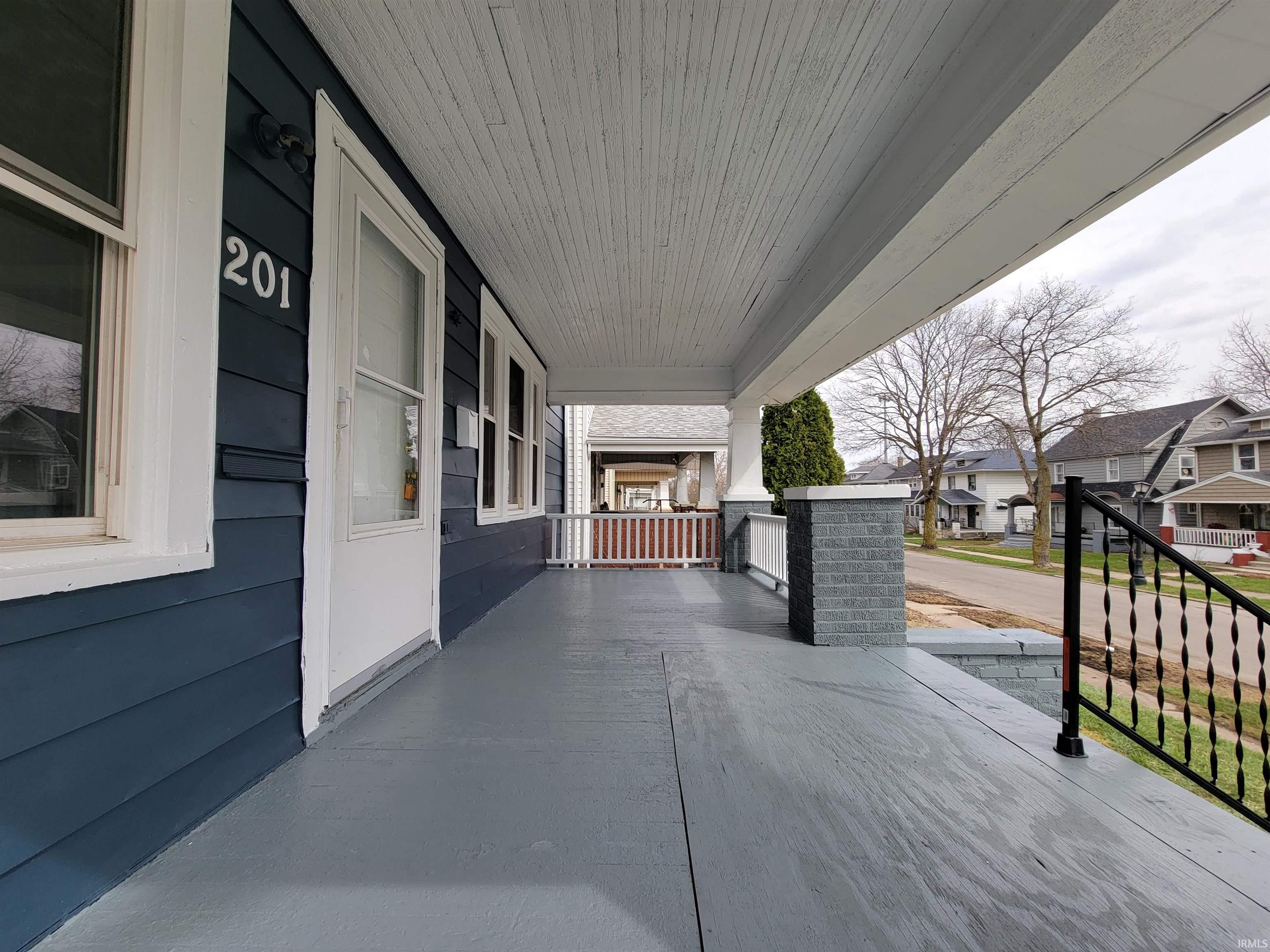 Covered porch featuring a residential view