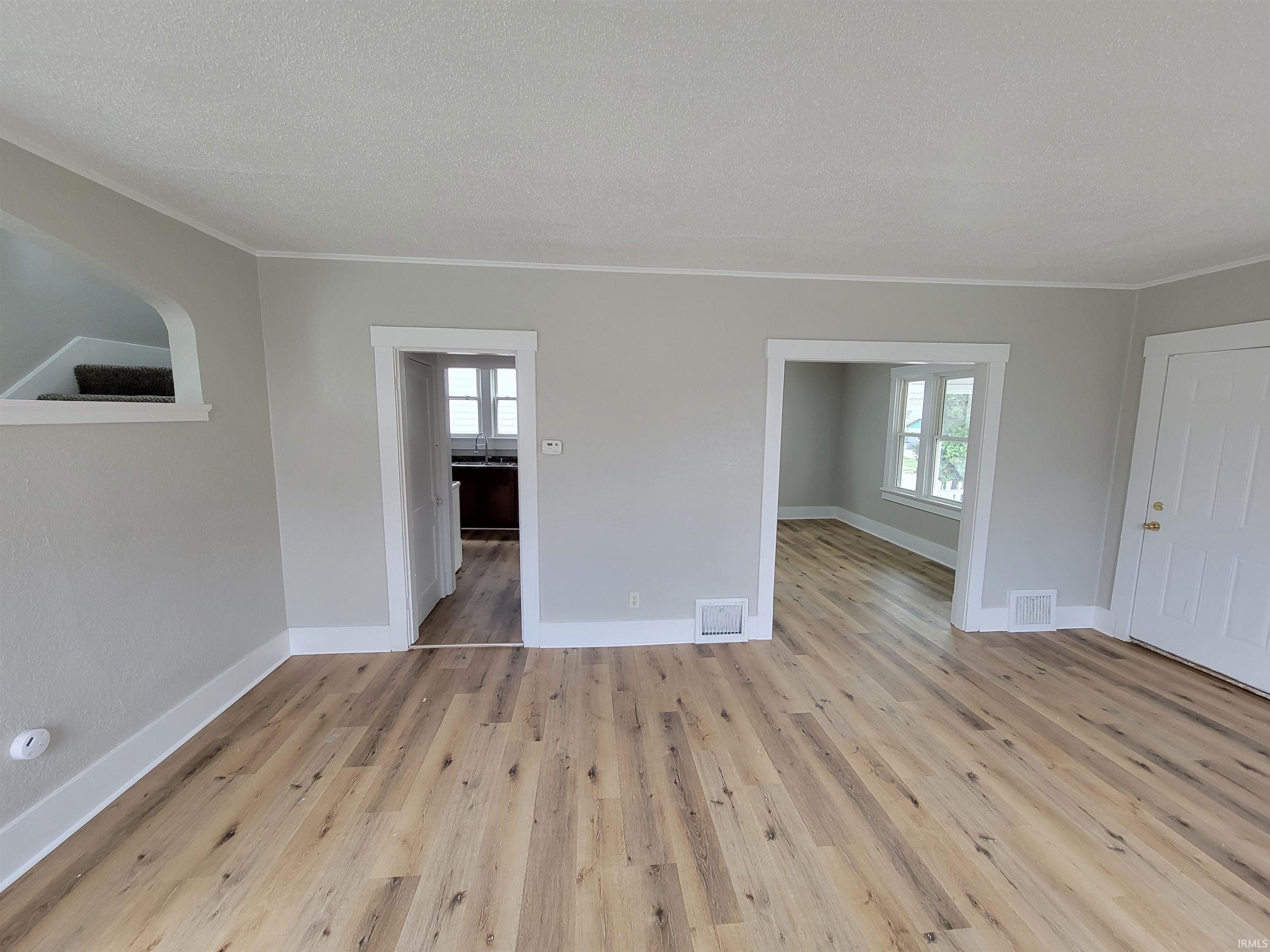 Spare room featuring light wood finished floors and a textured ceiling