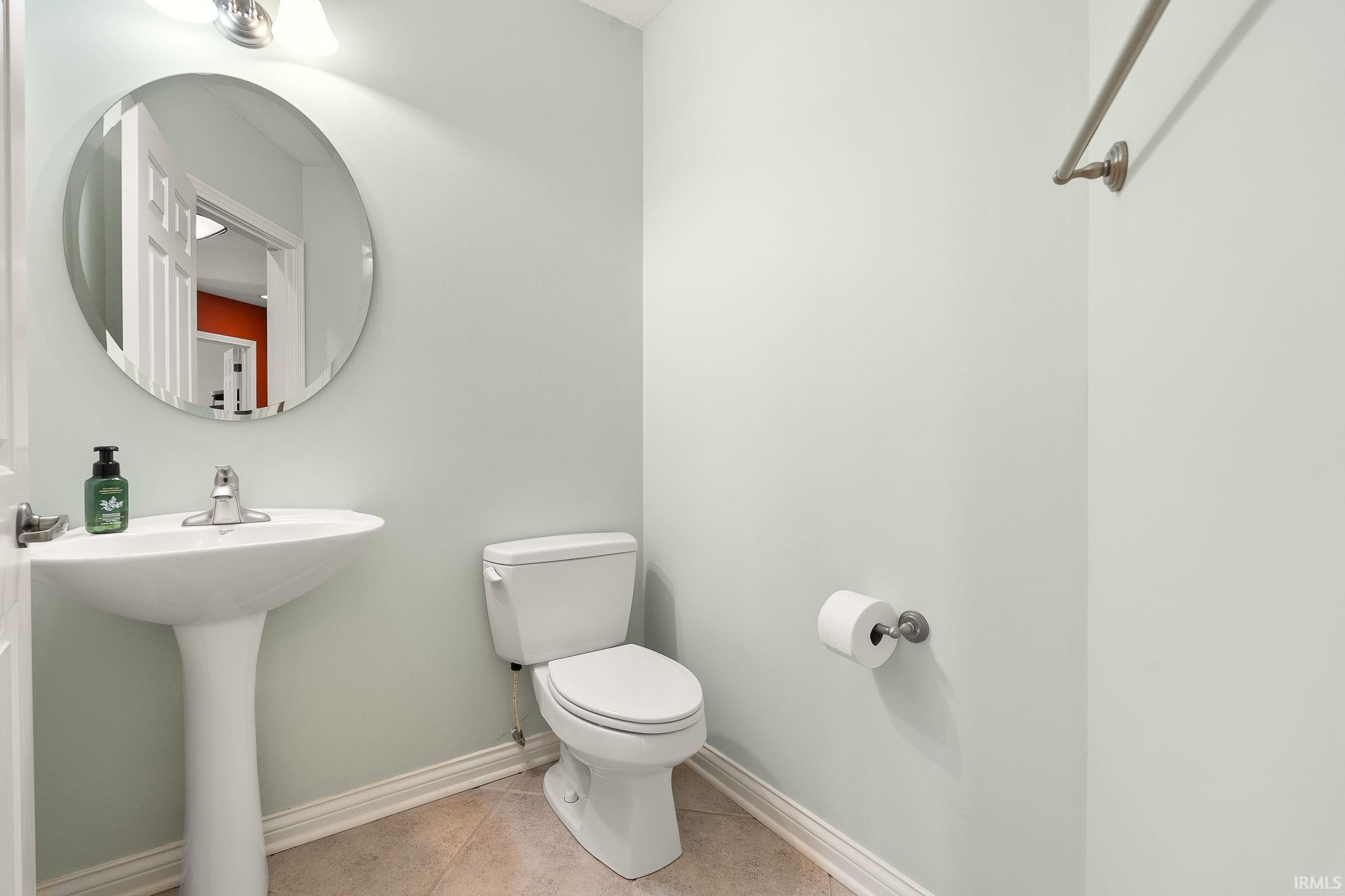Half bathroom featuring baseboards and light tile patterned floors