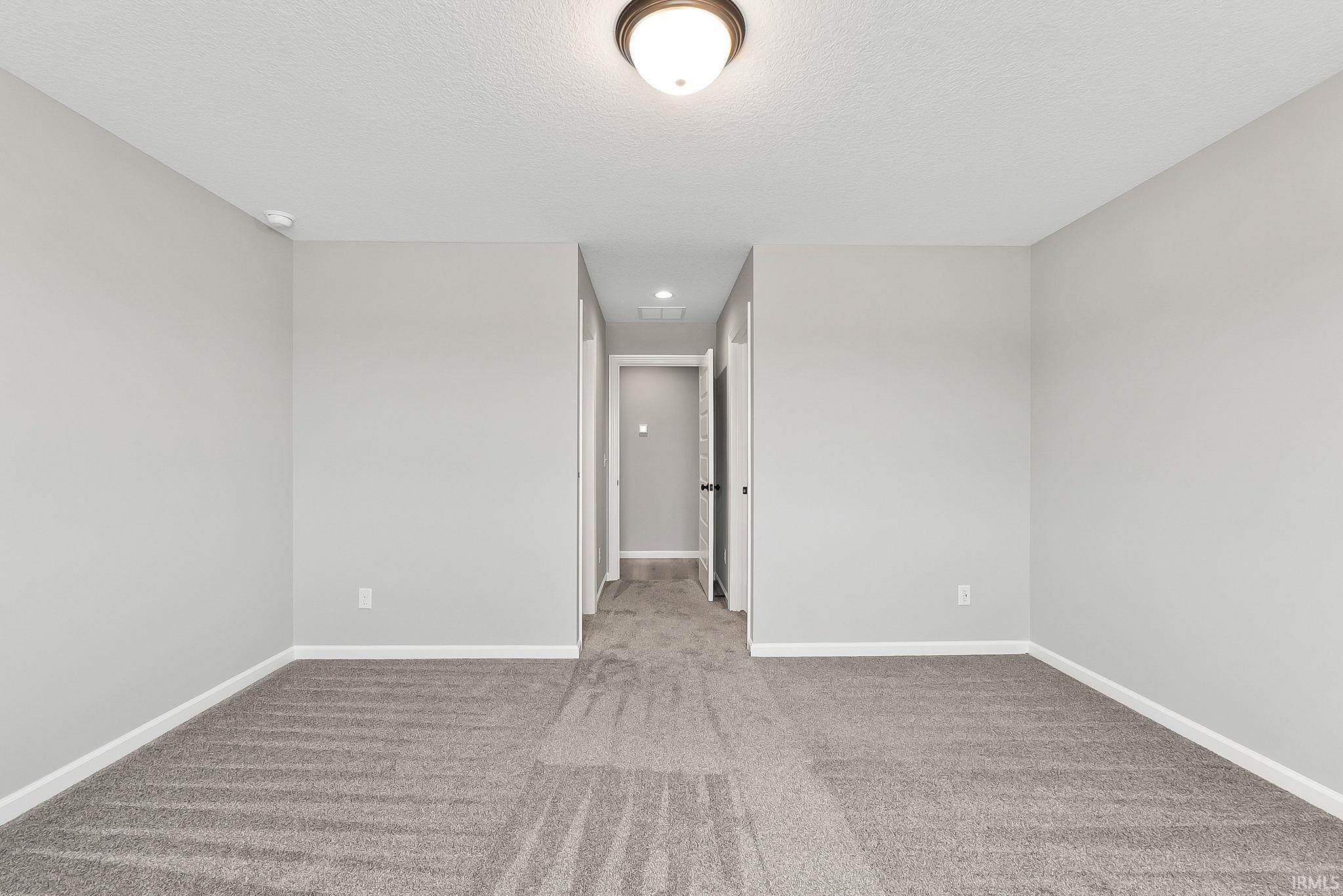 Unfurnished room with light carpet, recessed lighting, and a textured ceiling