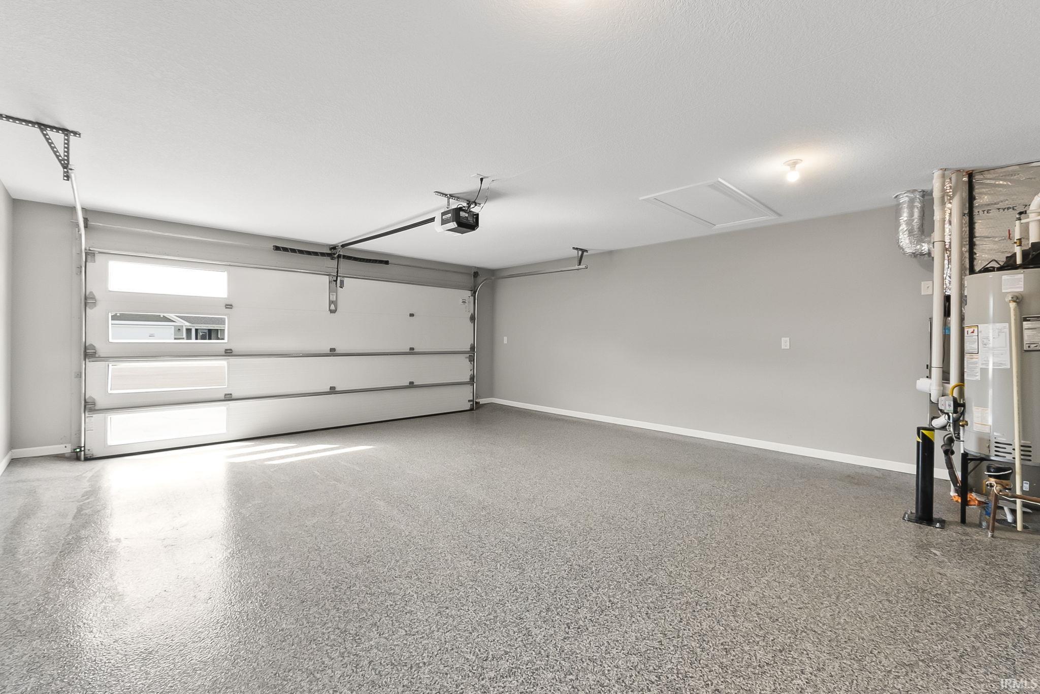 Garage with baseboards and gas water heater