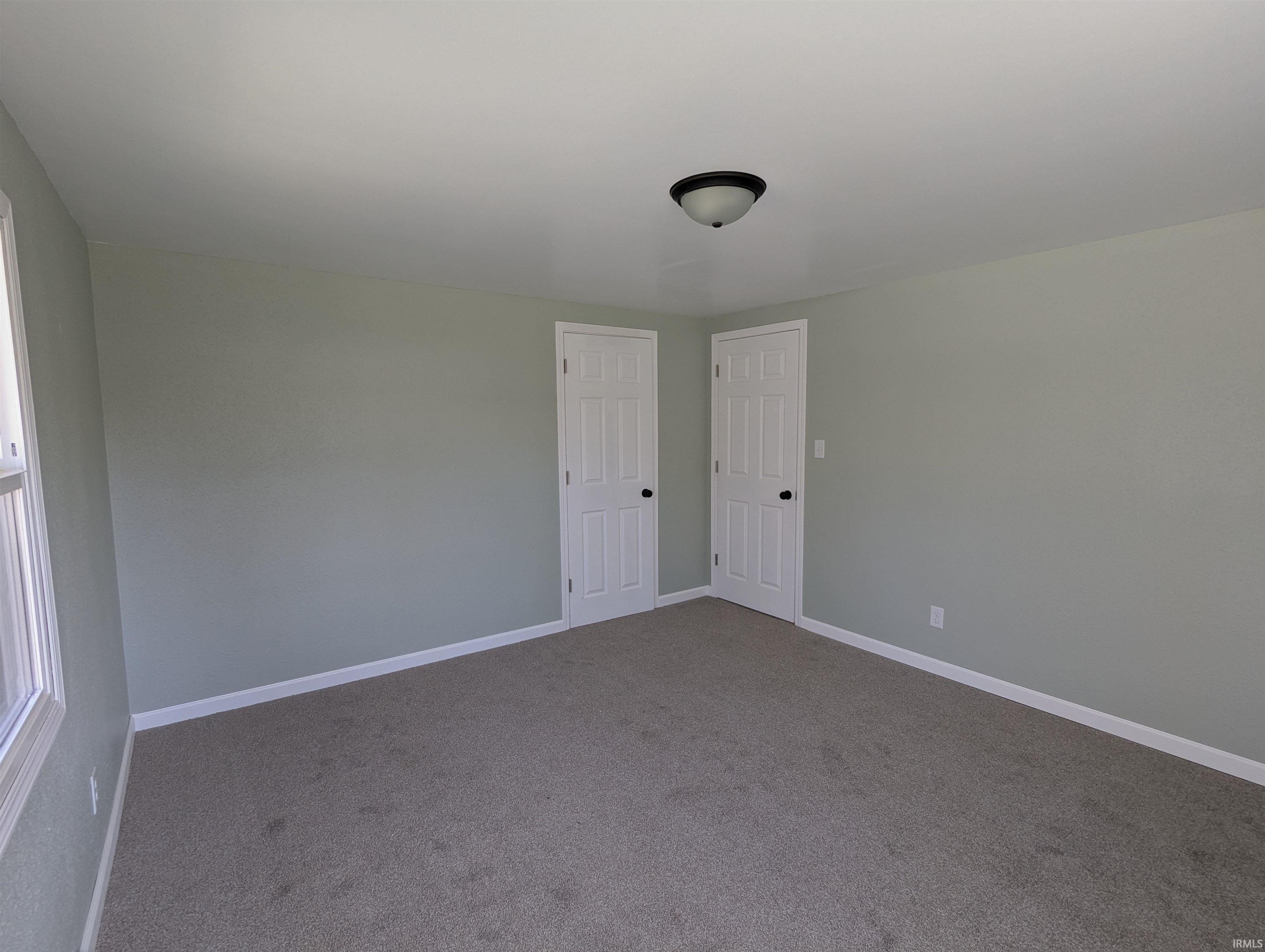 Empty room with carpet and baseboards