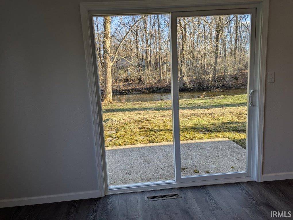 Entryway featuring a water view, view of scattered trees, and wood finished floors