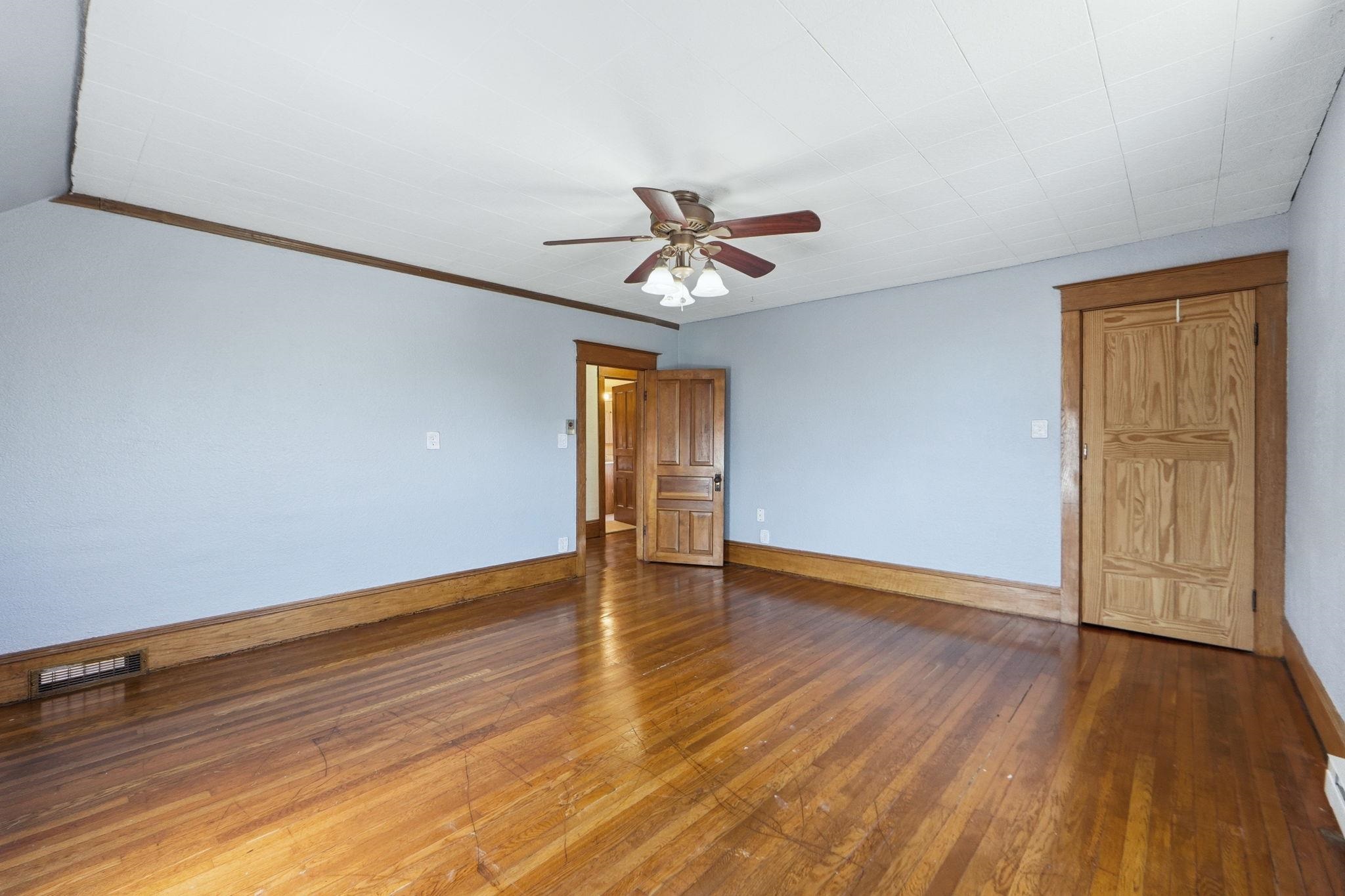 Spare room with dark wood-style flooring and ceiling fan