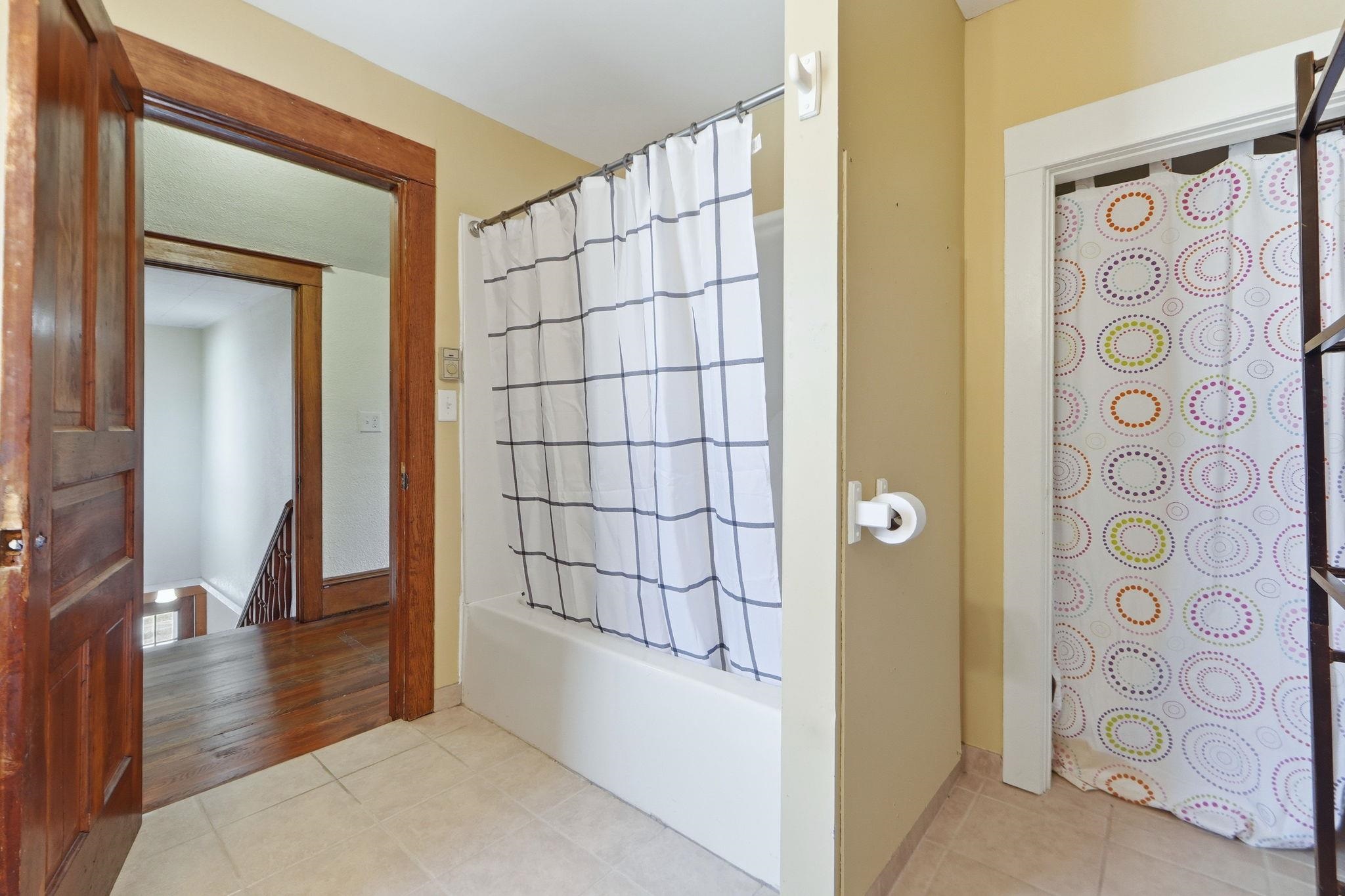 Full bath with light tile patterned floors and shower / bath combination with curtain
