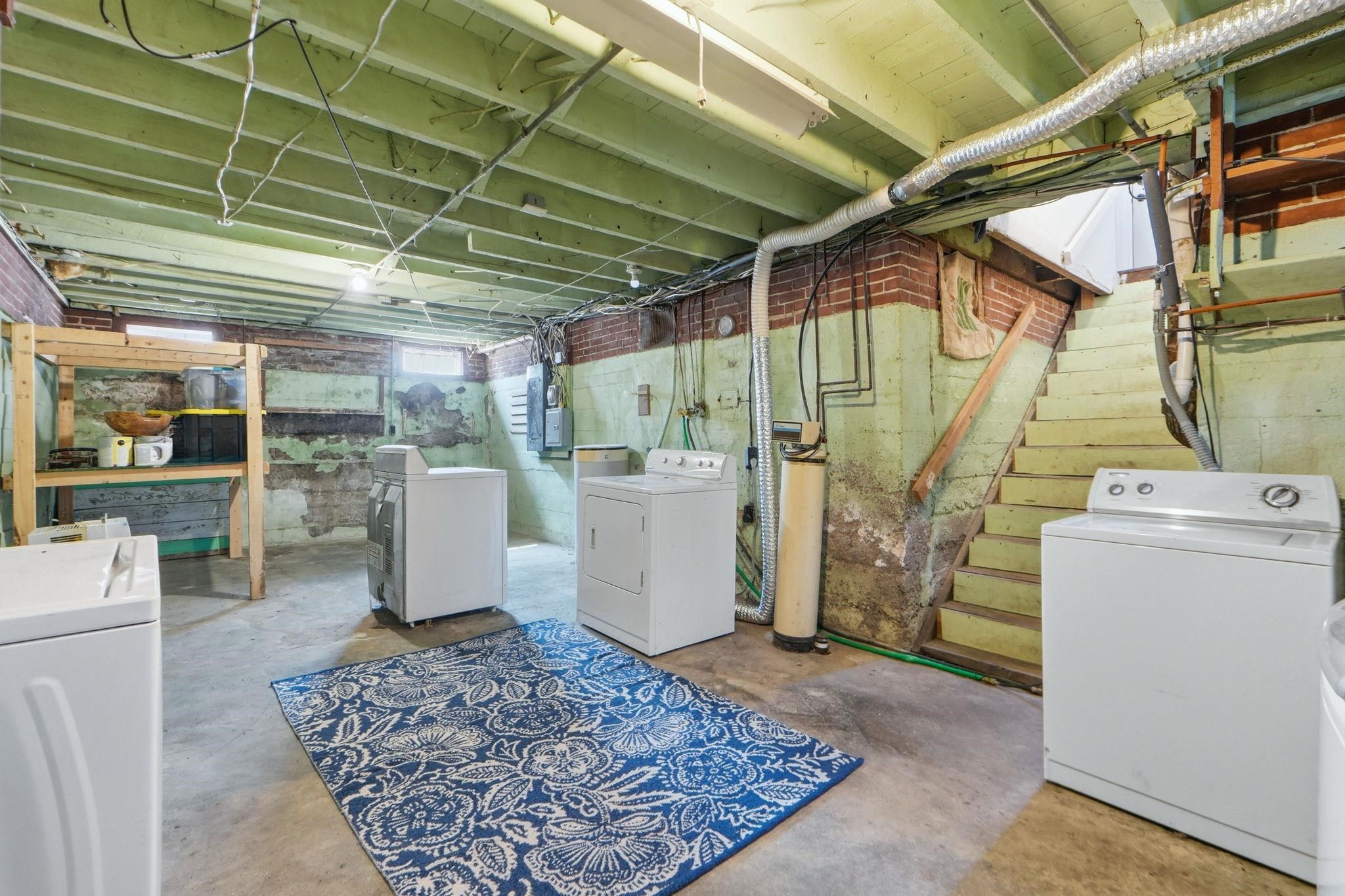 Unfinished below grade area with washing machine and dryer and a water softener