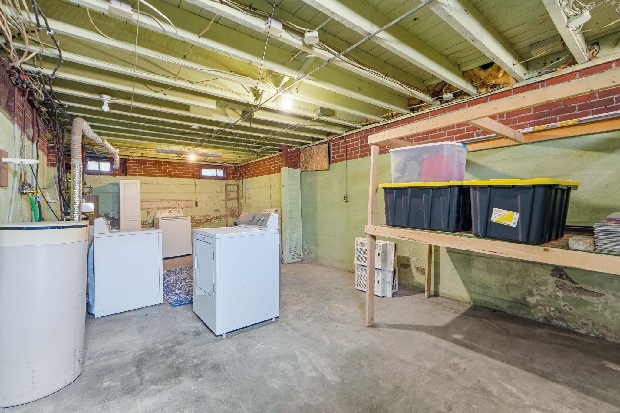 Unfinished below grade area with washing machine and dryer and a water softener