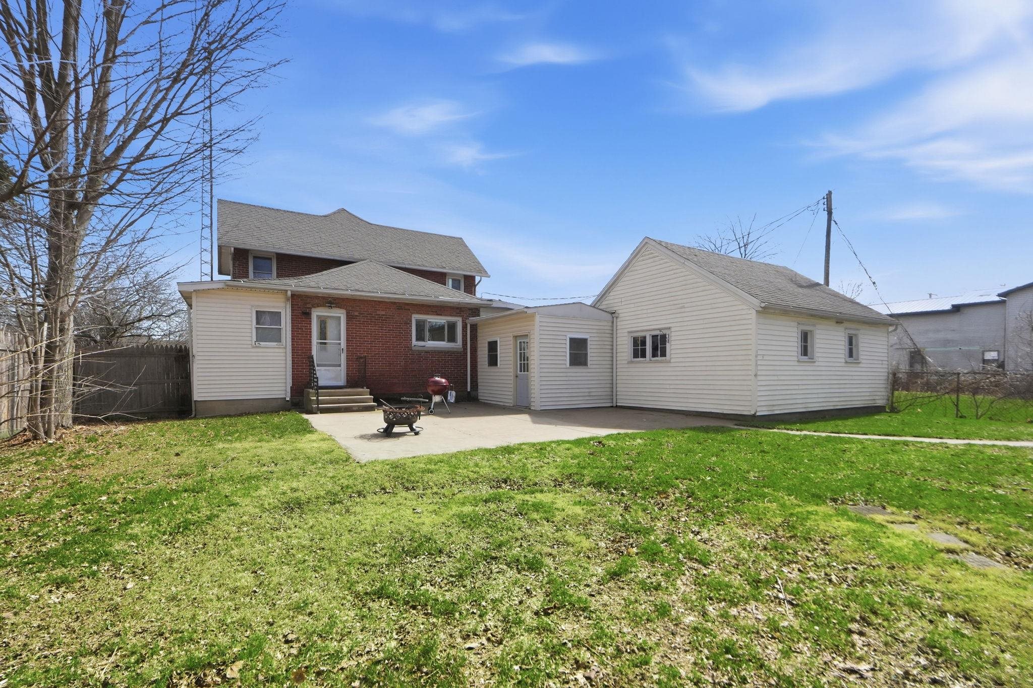 Rear view of property featuring a patio, entry steps, and brick siding