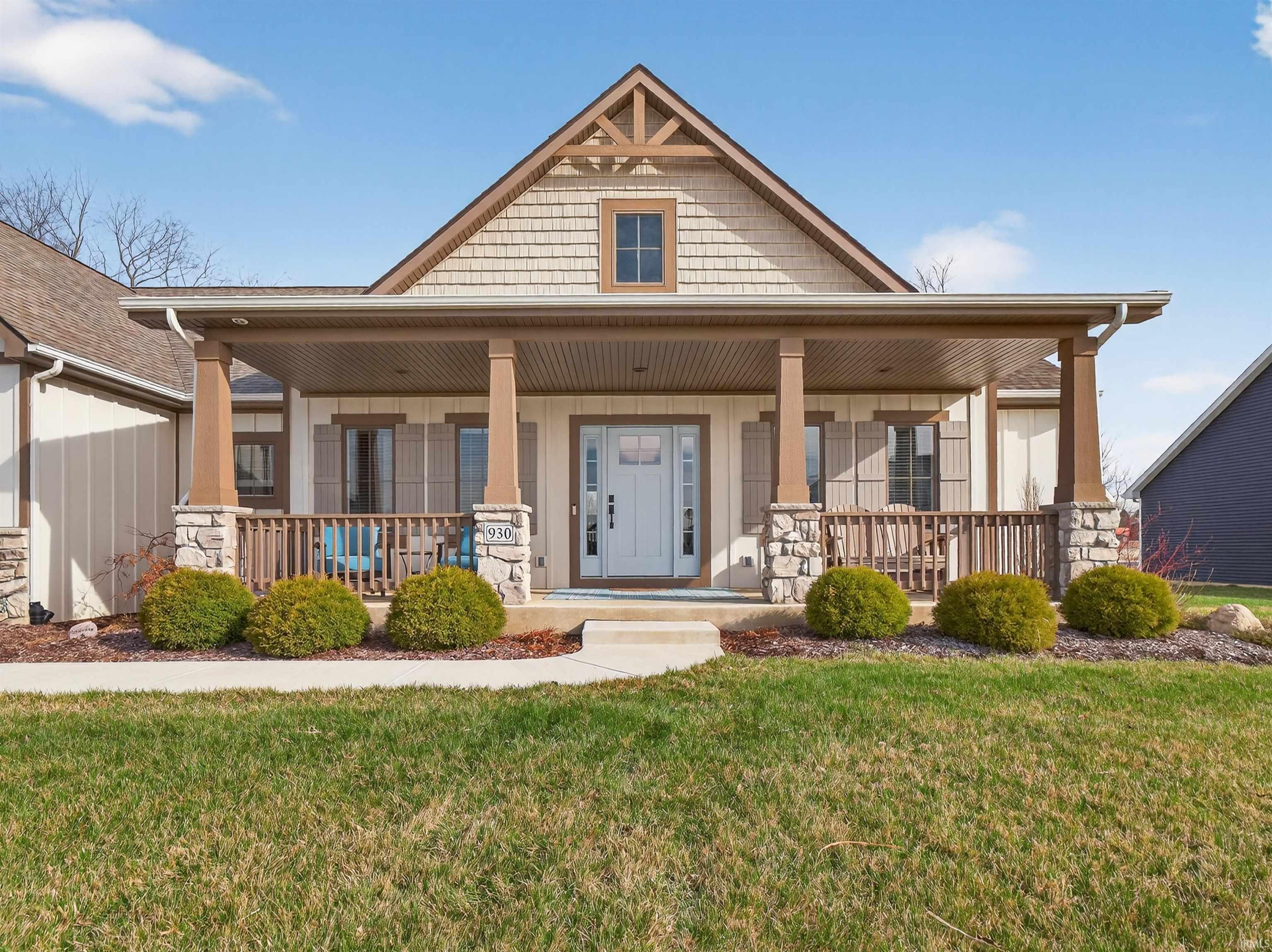 View of front of house with covered porch and a front lawn