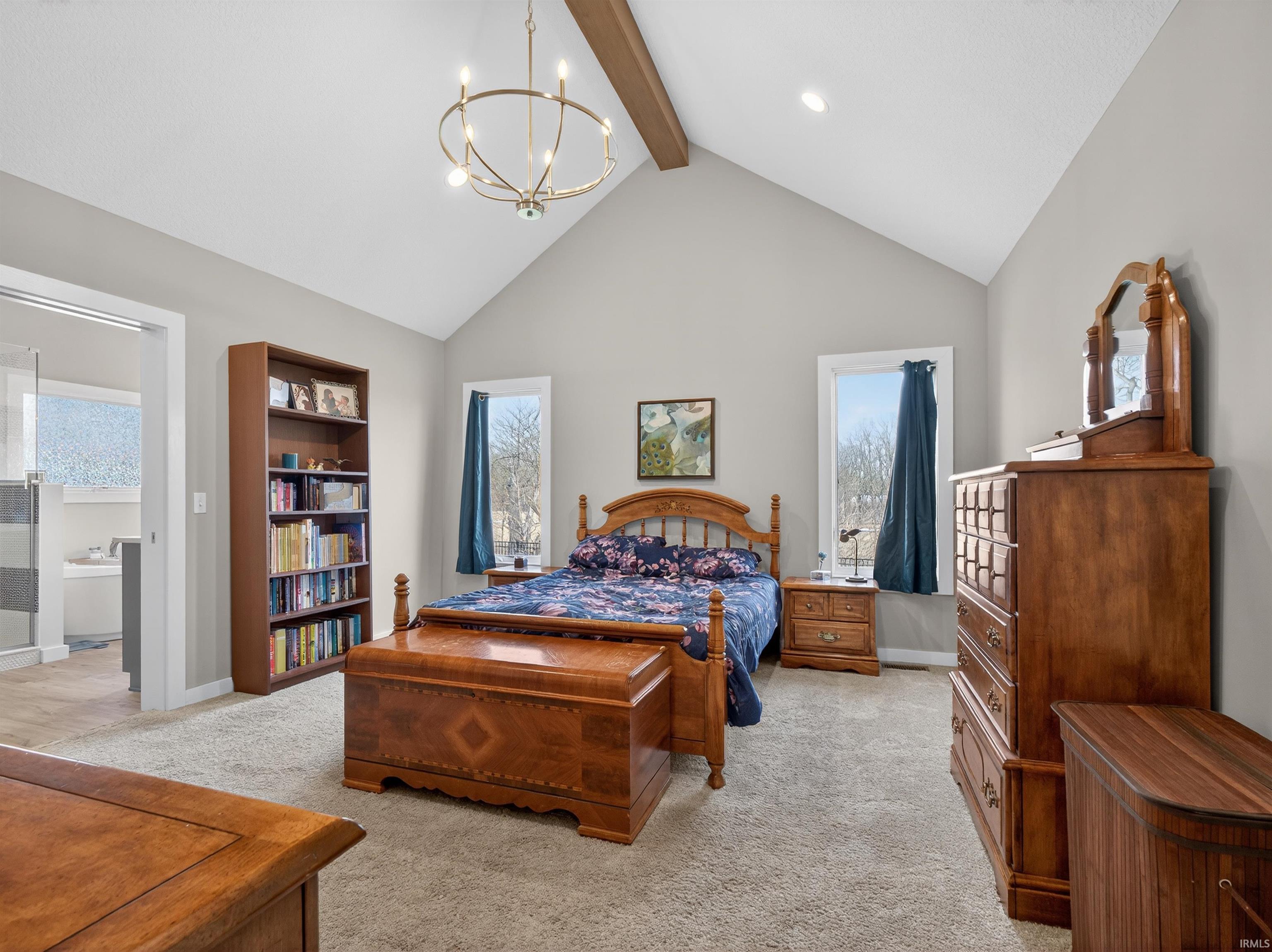 Bedroom with light carpet and suspended lighting