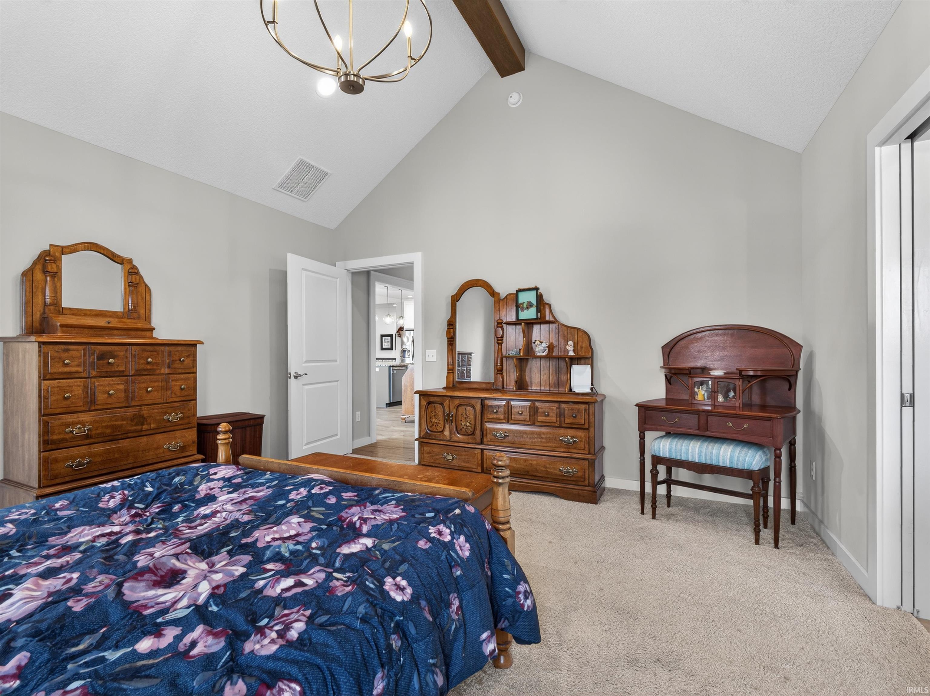Bedroom featuring hanging lights and light colored carpet