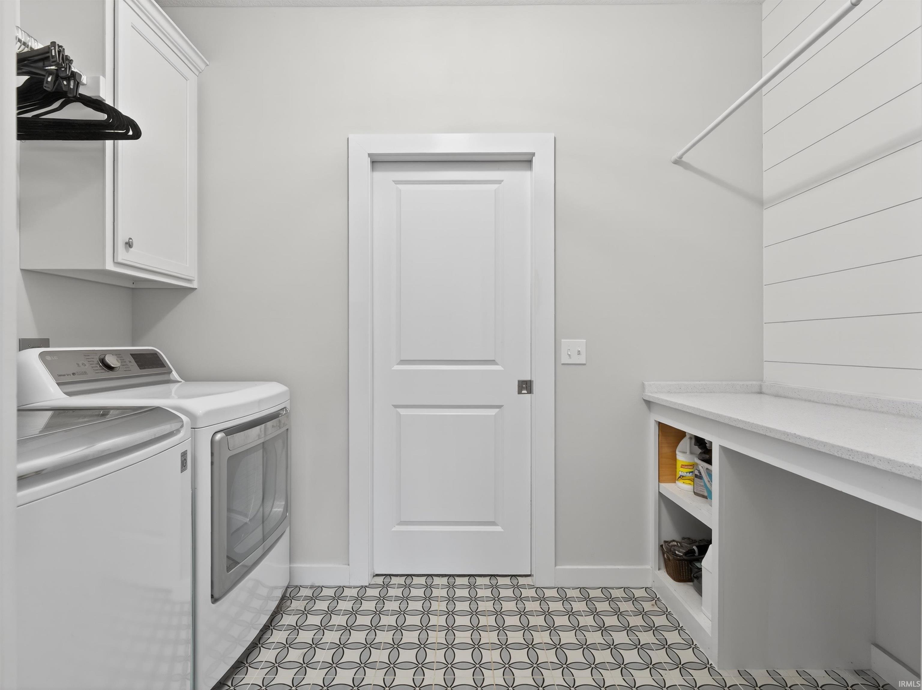 Laundry room featuring washing machine and clothes dryer and baseboards