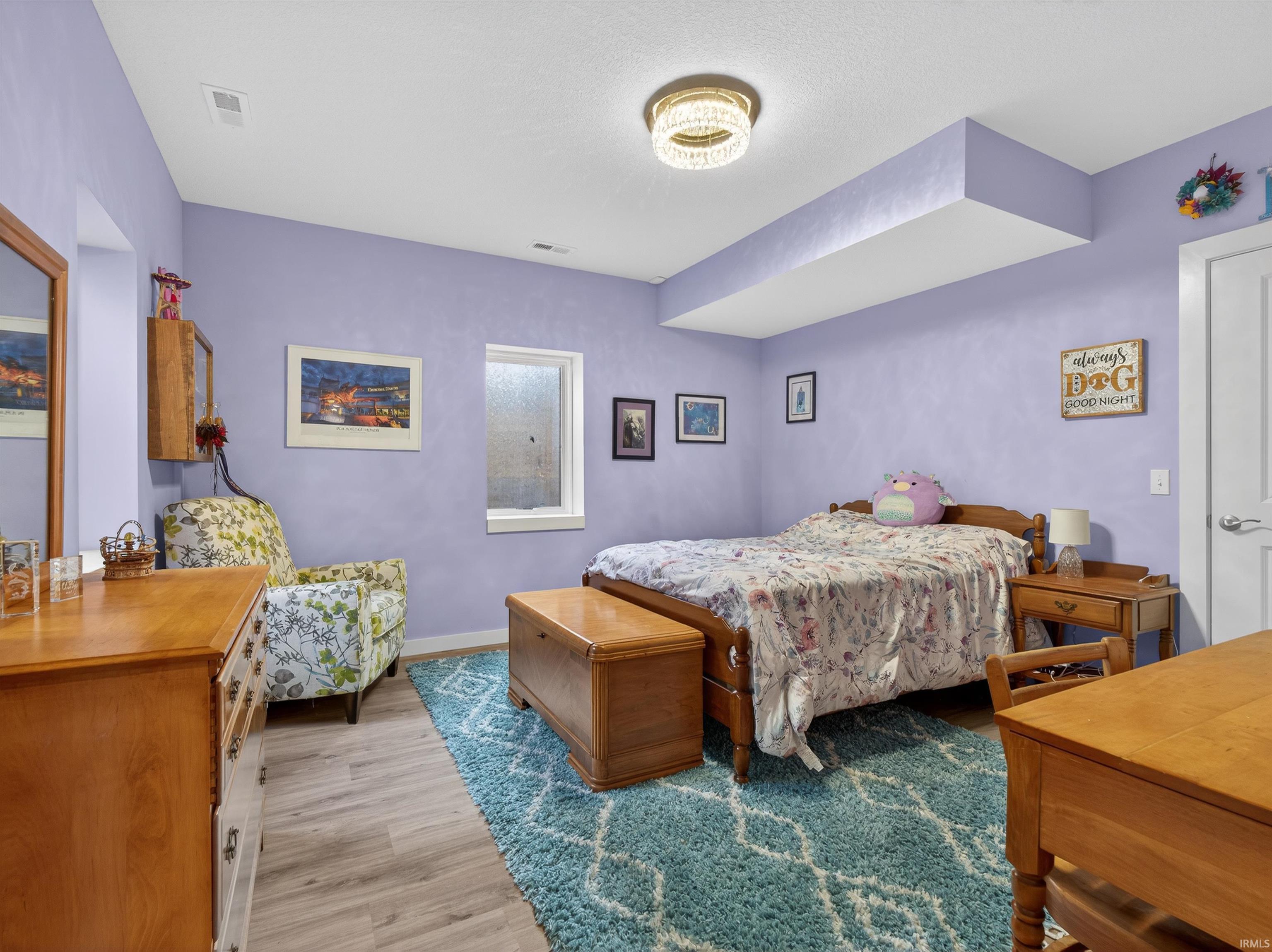 Bedroom with light wood finished floors and baseboards