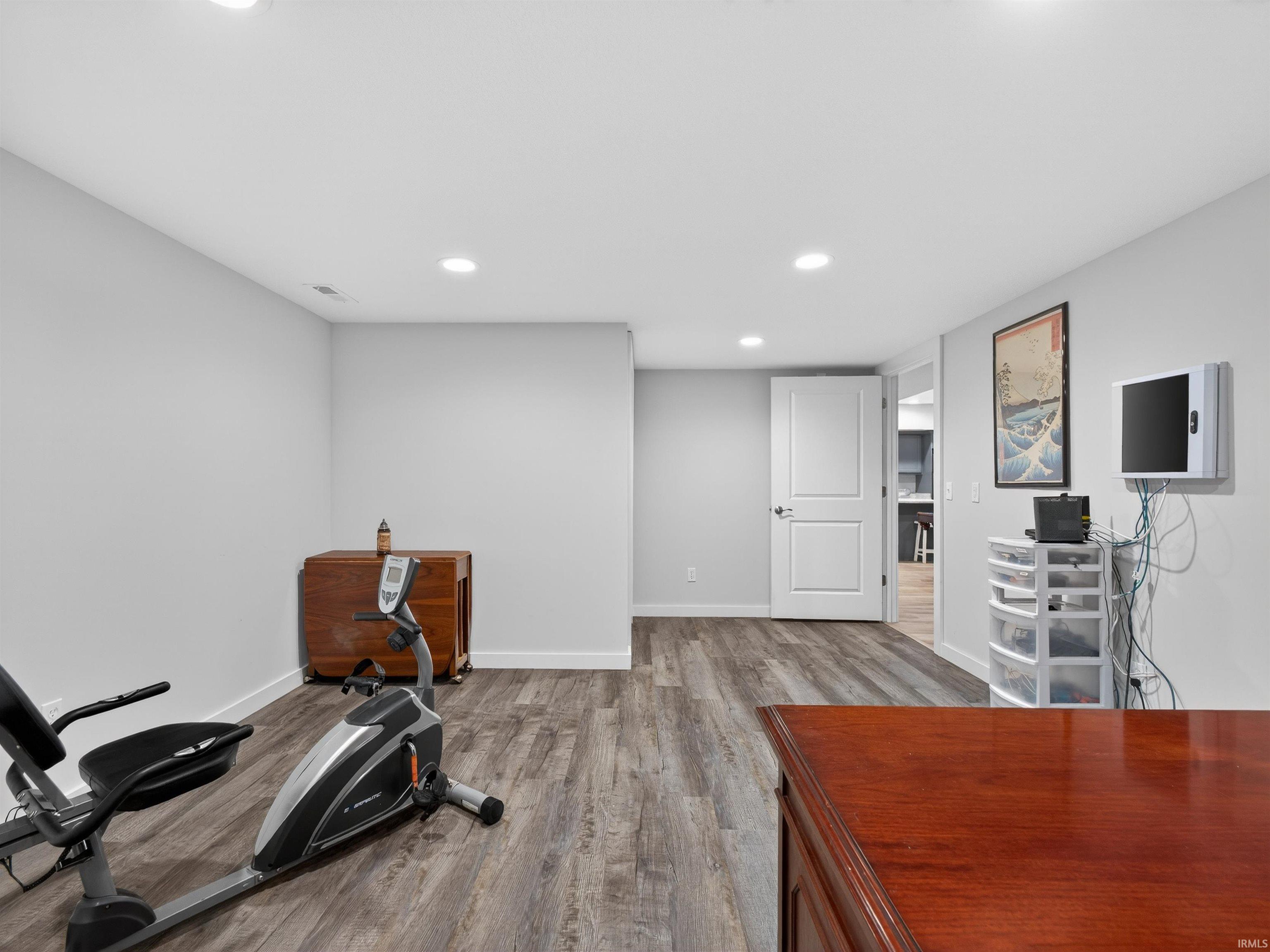 Exercise room featuring light wood finished floors and recessed lighting