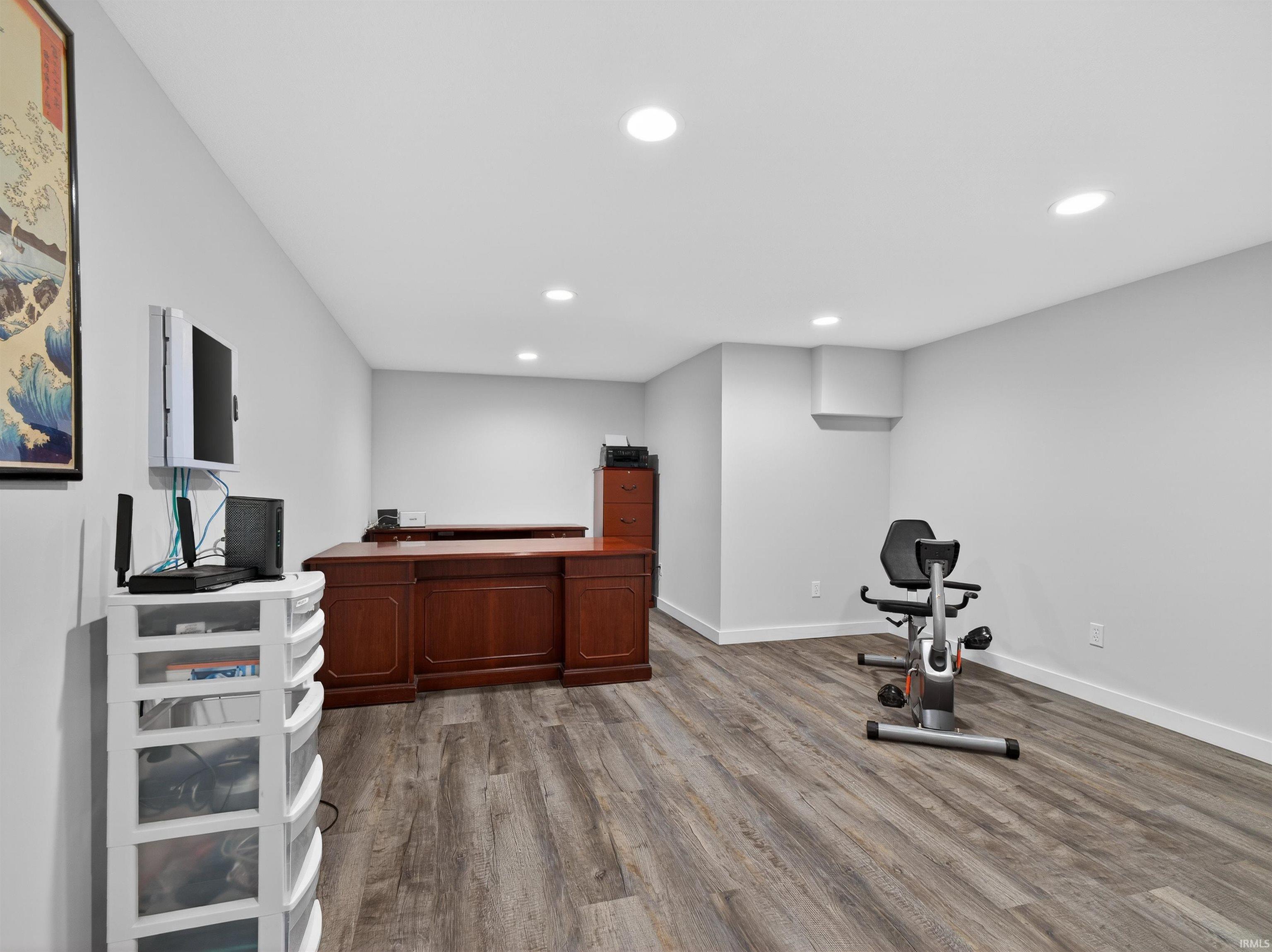 Office space with dark wood finished floors and recessed lighting