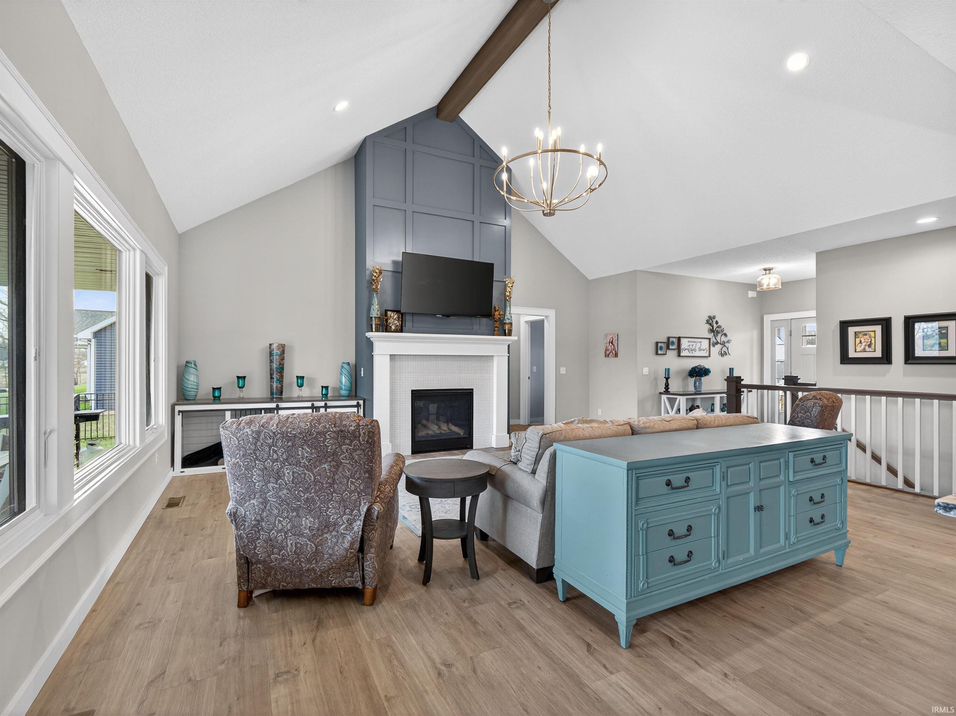 Living area featuring a fireplace, suspended lighting, and light wood-style floors