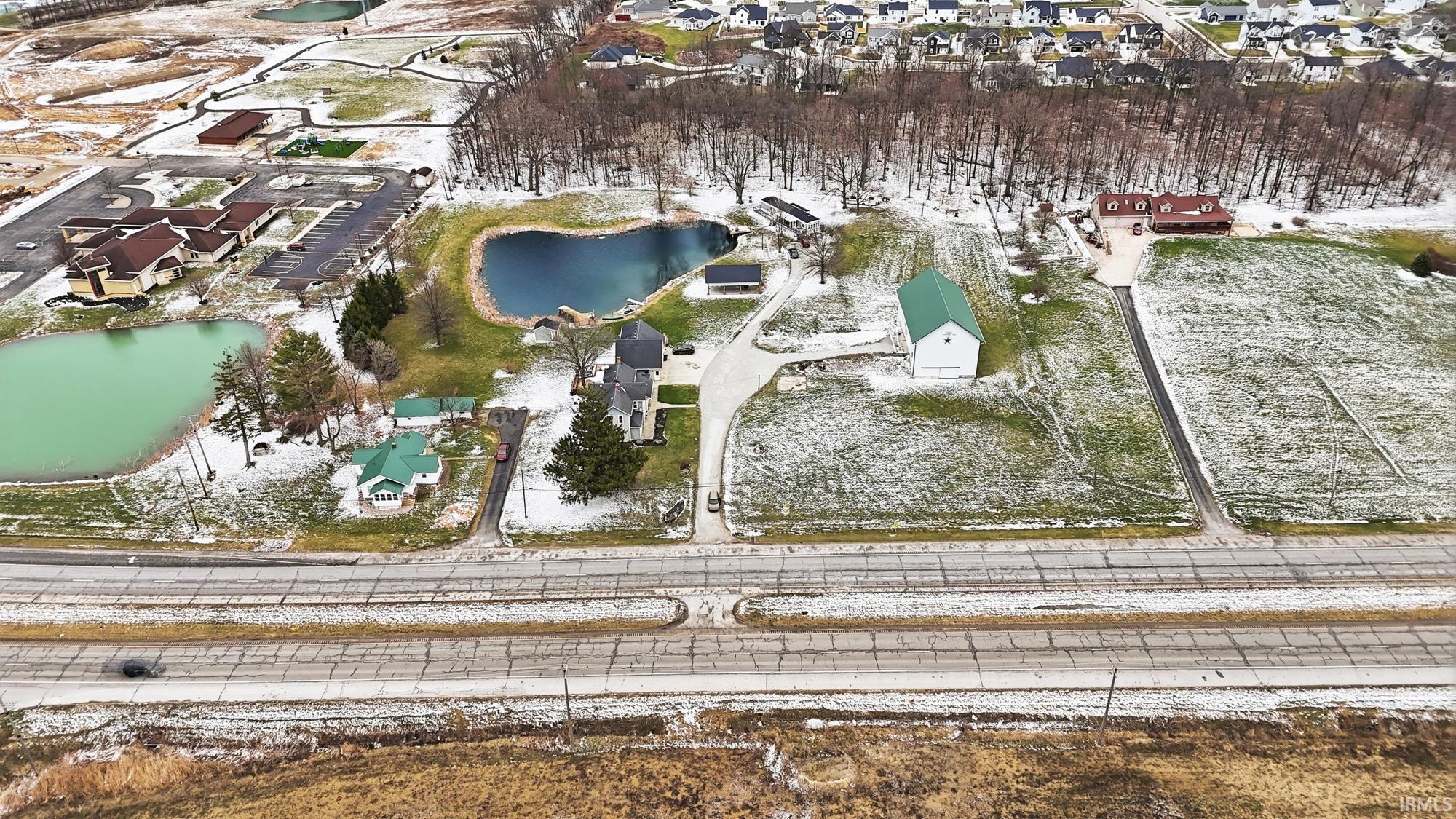 Aerial view of property and surrounding area with nearby suburban area and a large body of water