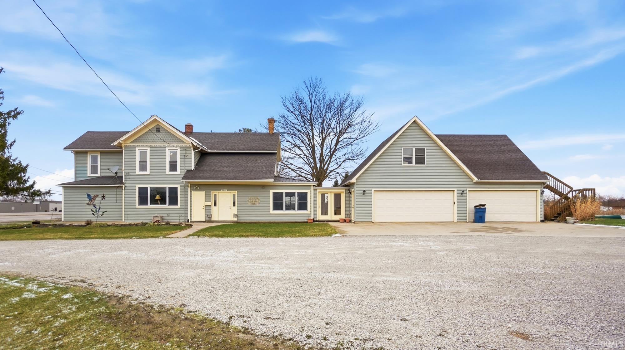 Traditional-style house with concrete driveway, a chimney, a shingled roof, and a front yard