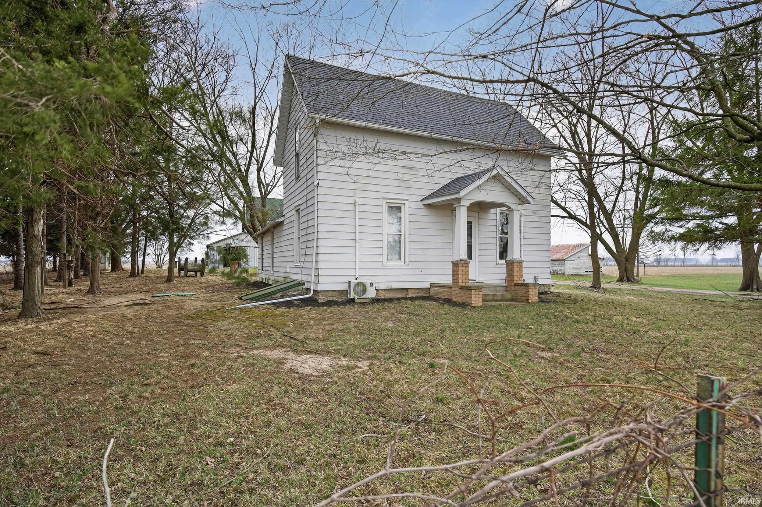 View of front facade featuring roof with shingles and a front lawn