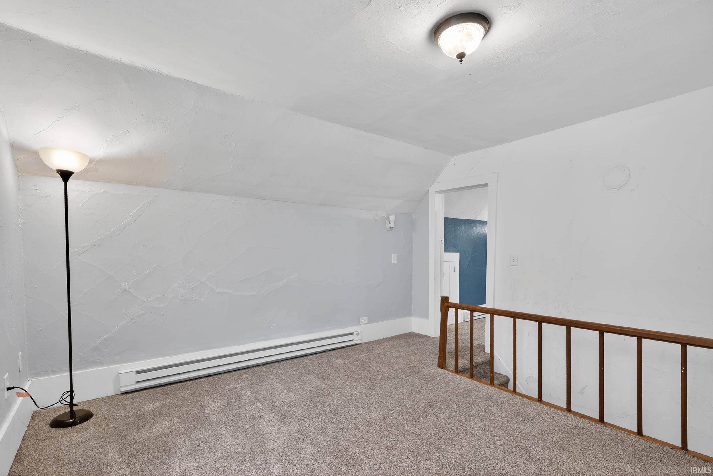 Bonus room with carpet floors, a baseboard radiator, and lofted ceiling
