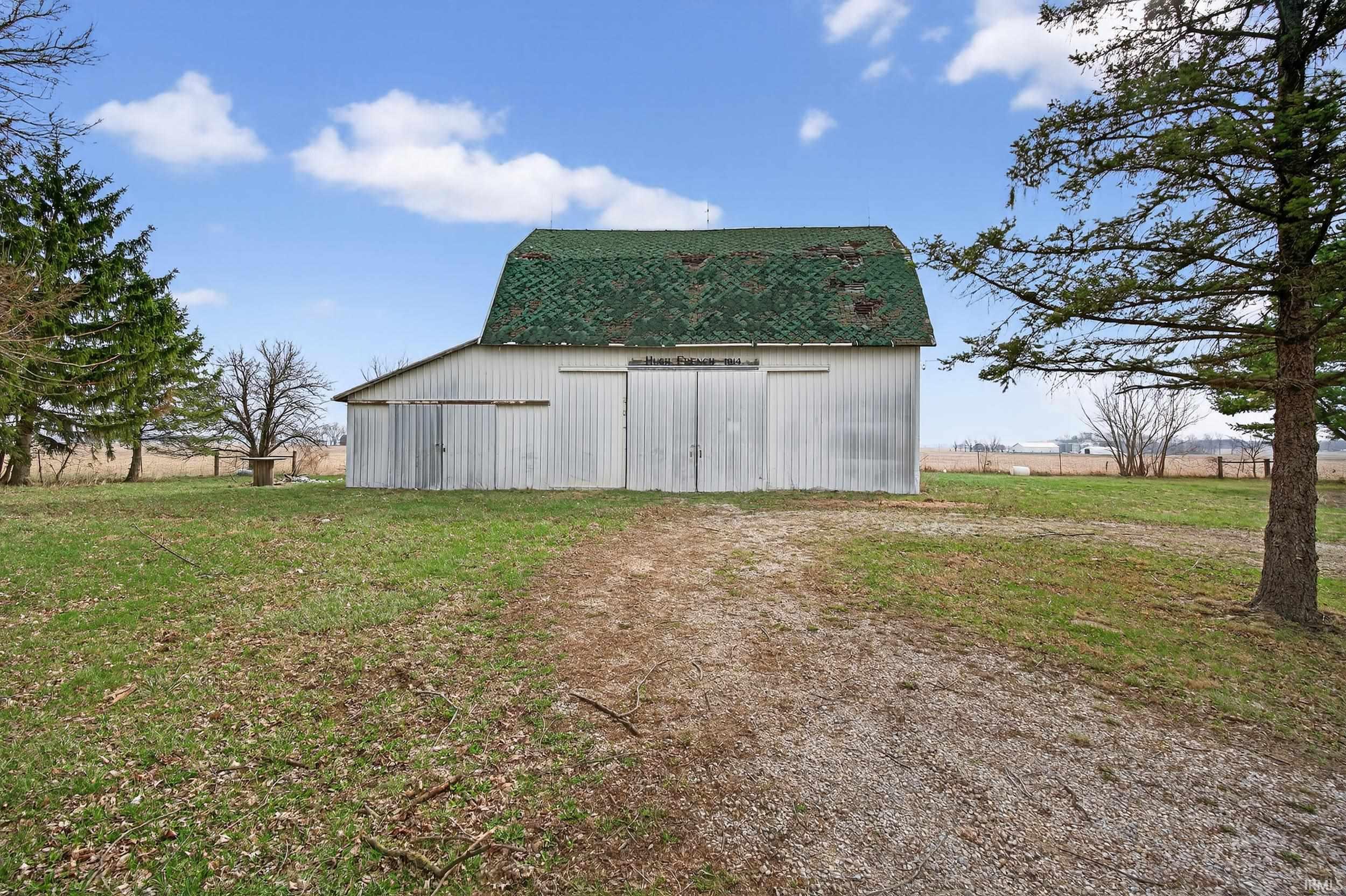 View of outdoor structure with dirt driveway