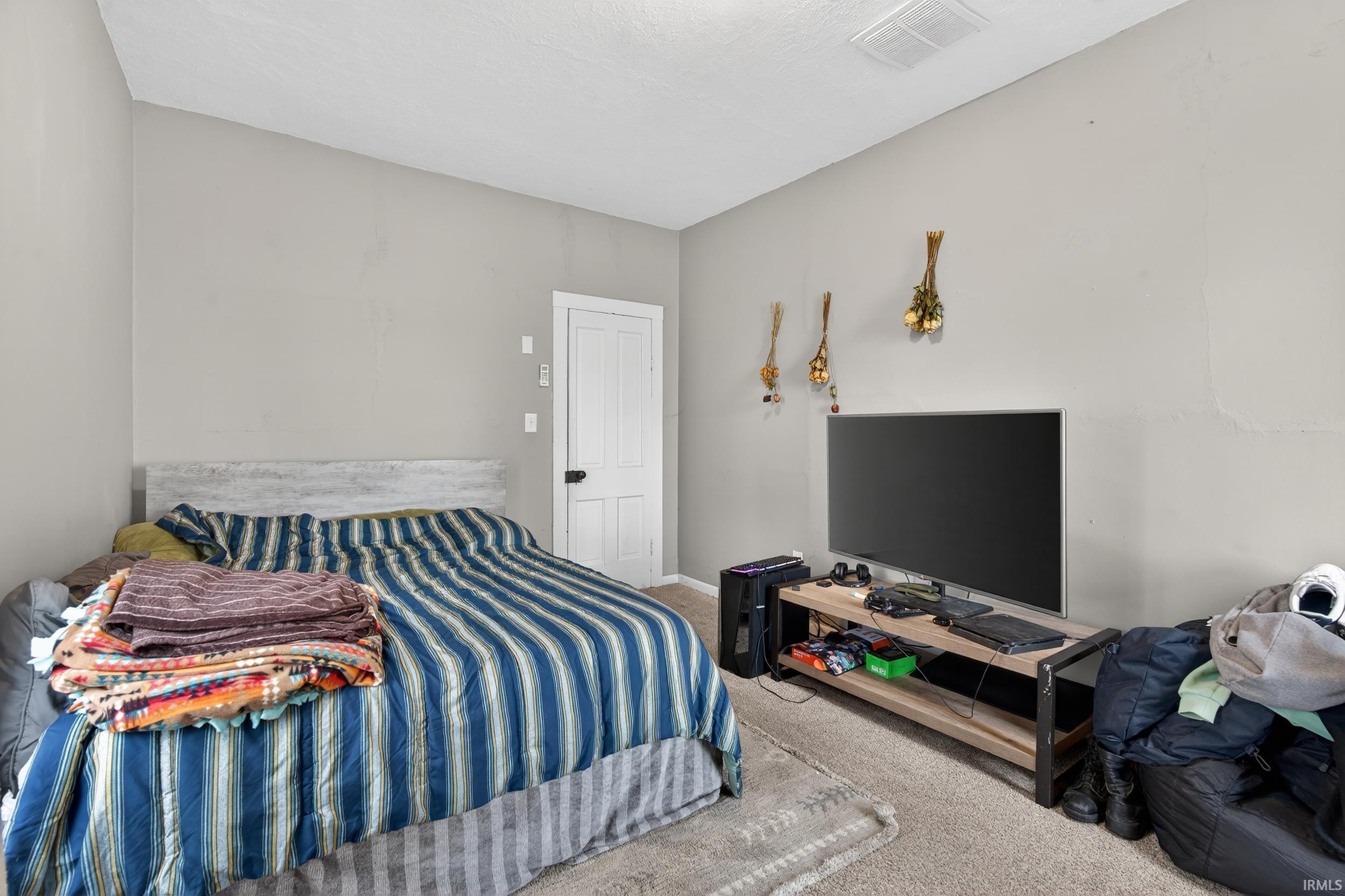 Bedroom featuring carpet and baseboards