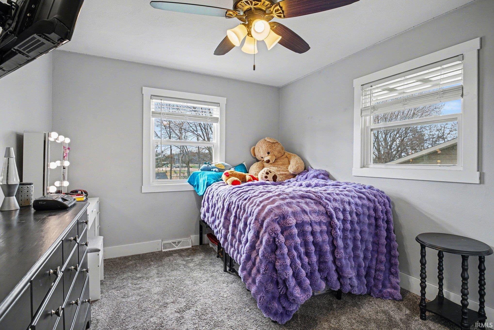 Bedroom with dark carpet and ceiling fan