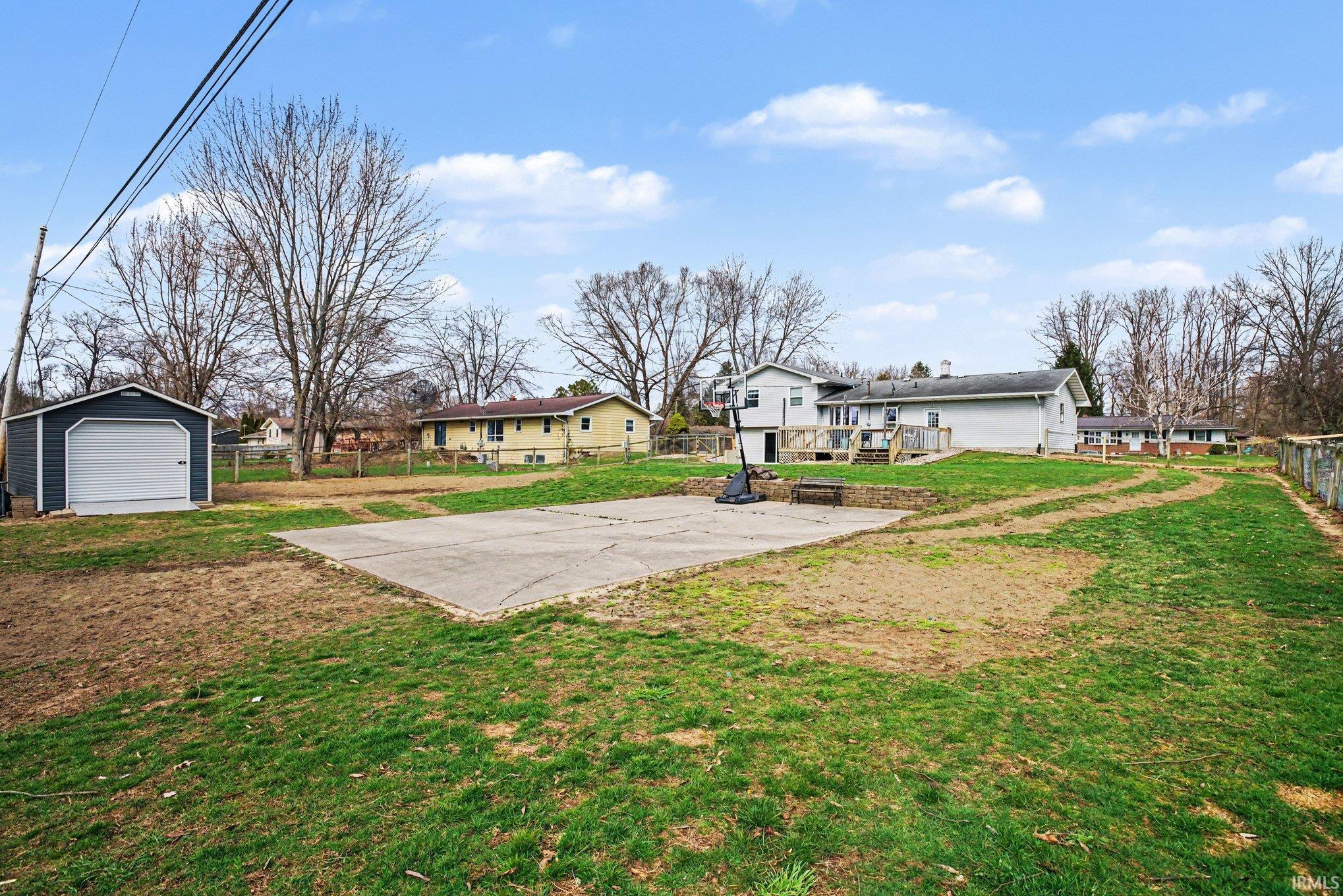 Fenced yard featuring an outdoor structure, a patio area, and a residential view