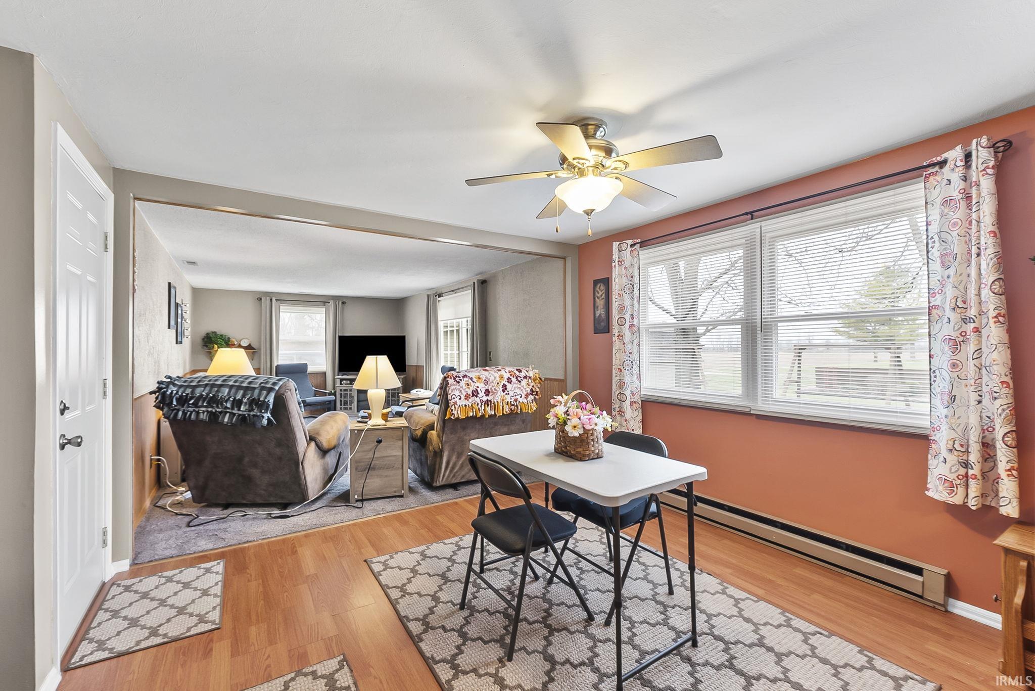 Dining area featuring a baseboard heating unit, light wood-style floors, and a ceiling fan