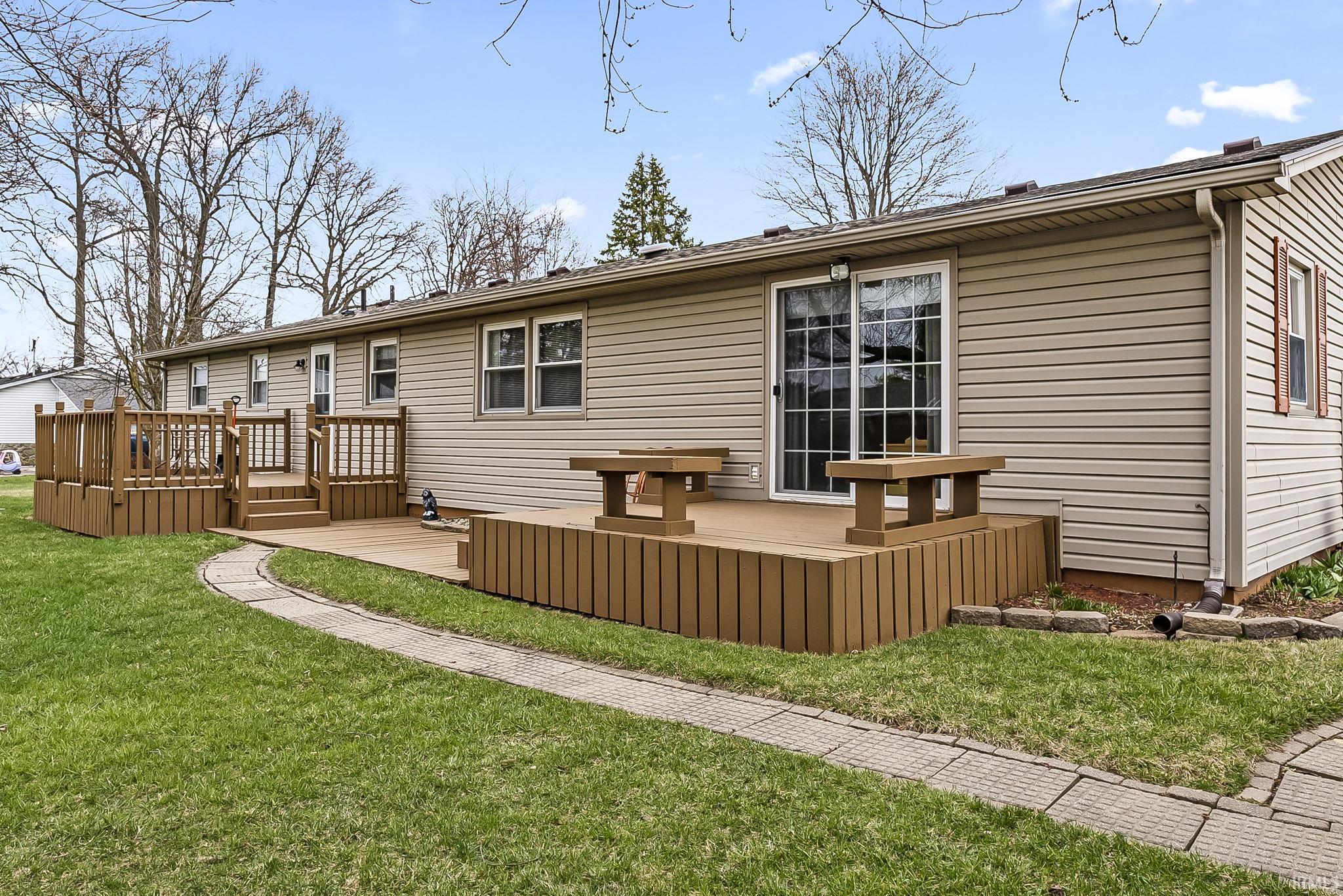Rear view of property with a wooden deck and a yard