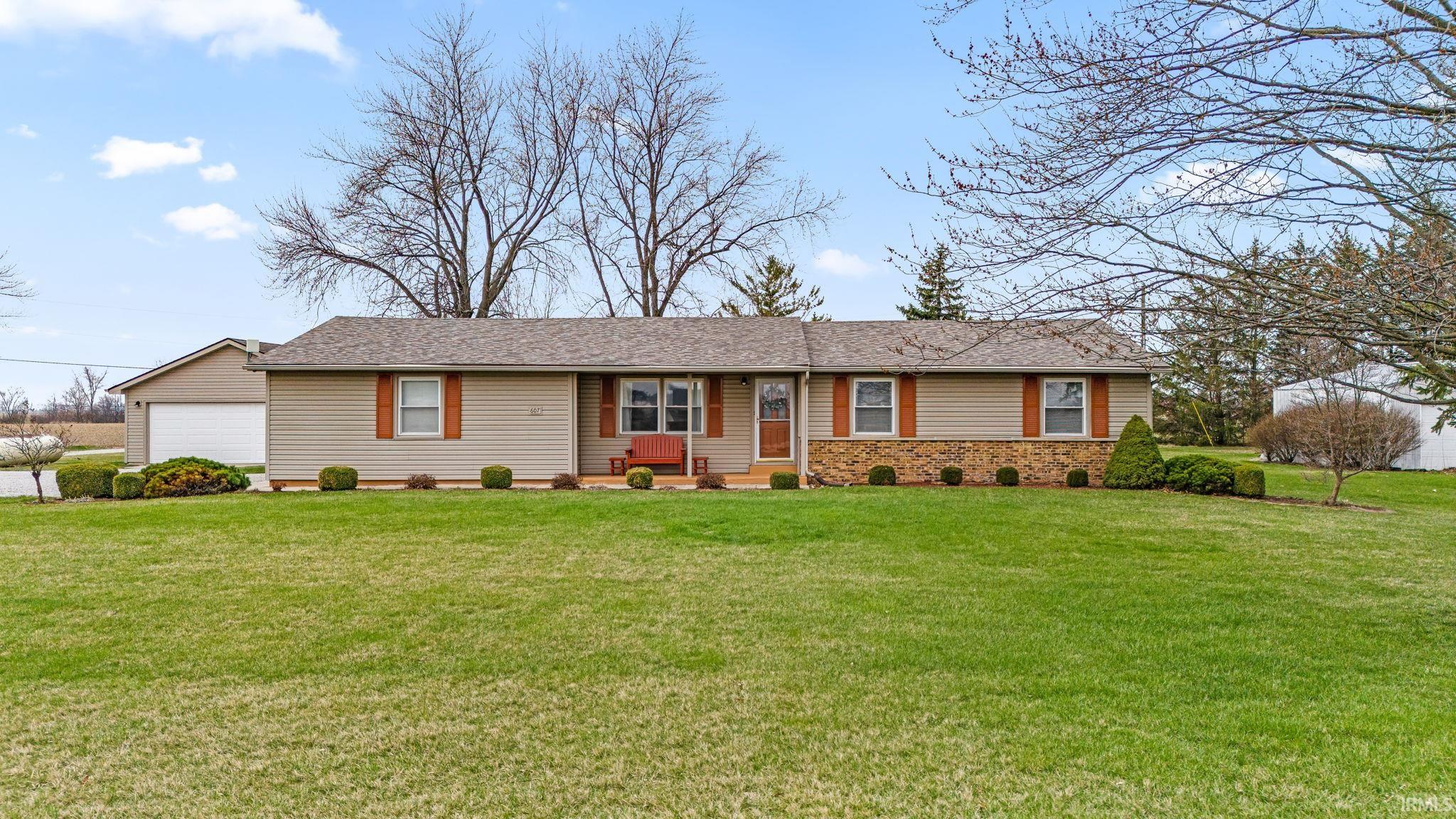 Single story home with a front lawn, a garage, and entry steps