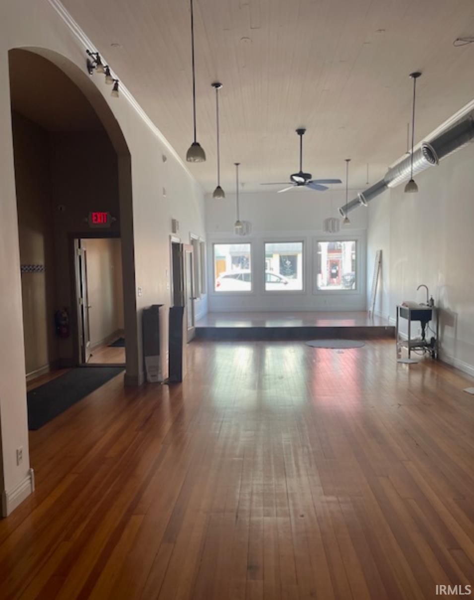 Miscellaneous room with a ceiling fan, arched walkways, and a high wooden ceiling