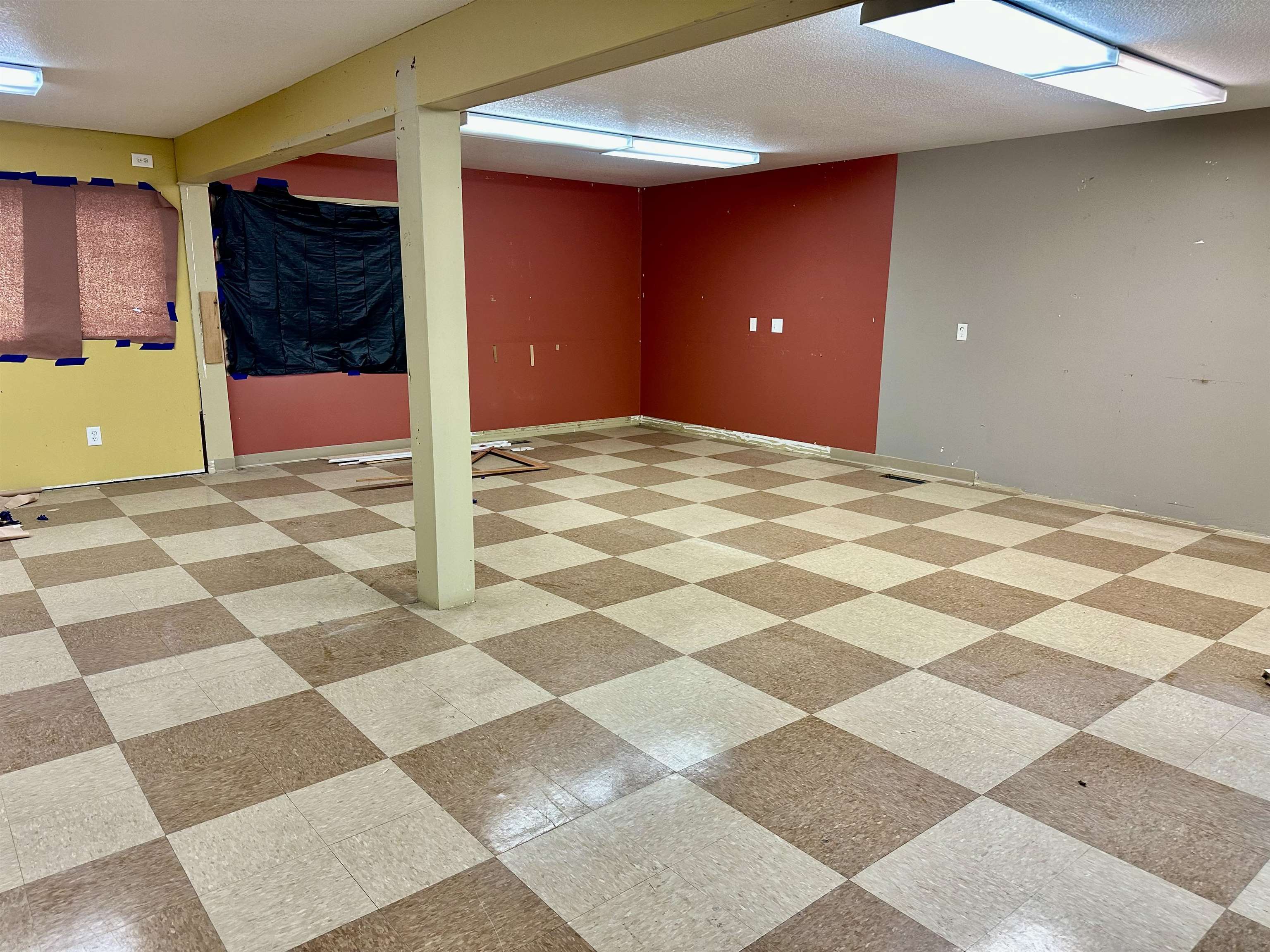 Finished basement featuring light floors and a textured ceiling