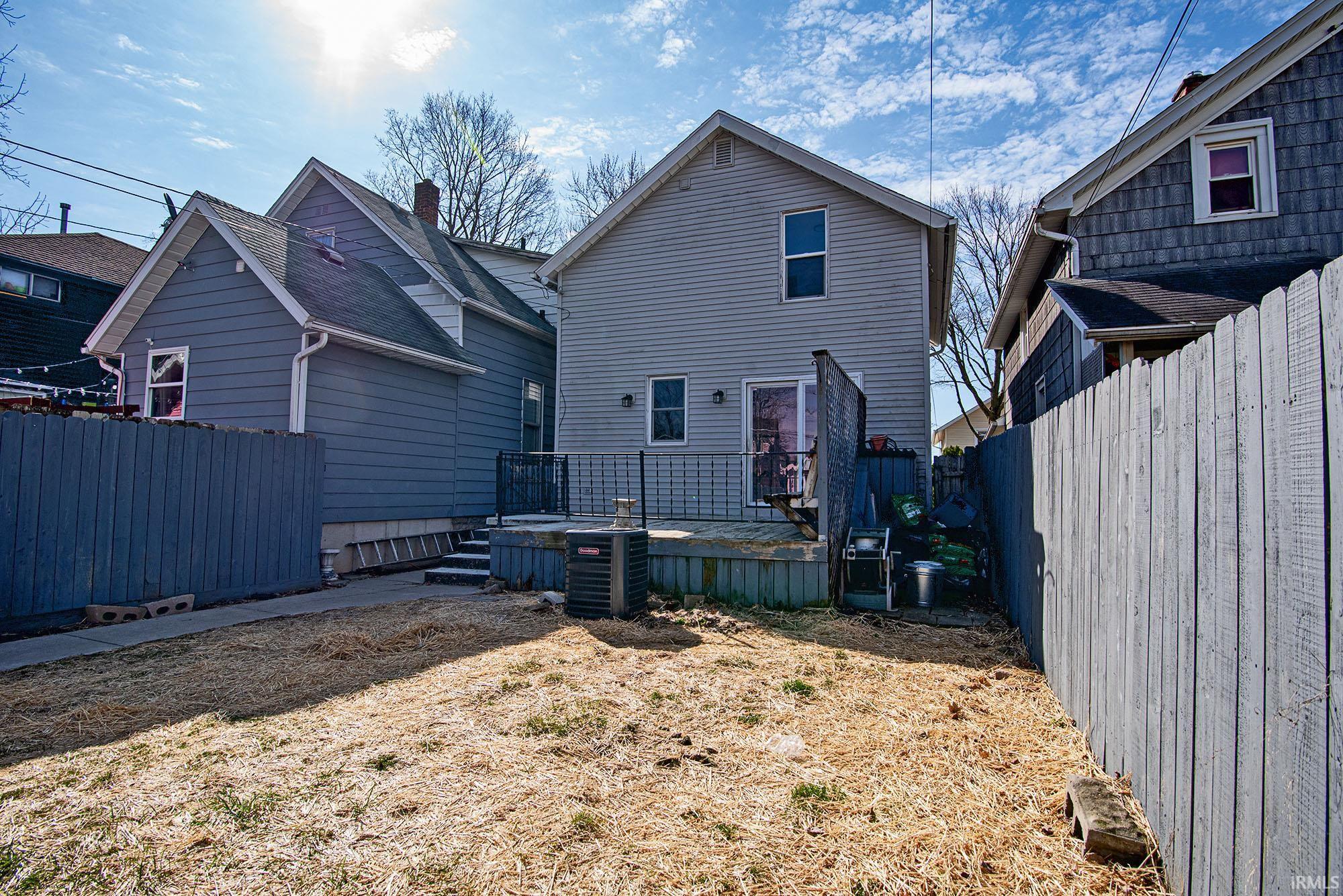 Rear view of house with a fenced backyard and a deck