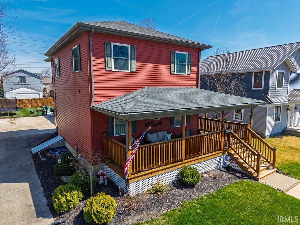 View of front of property featuring a shingled roof and a front yard
