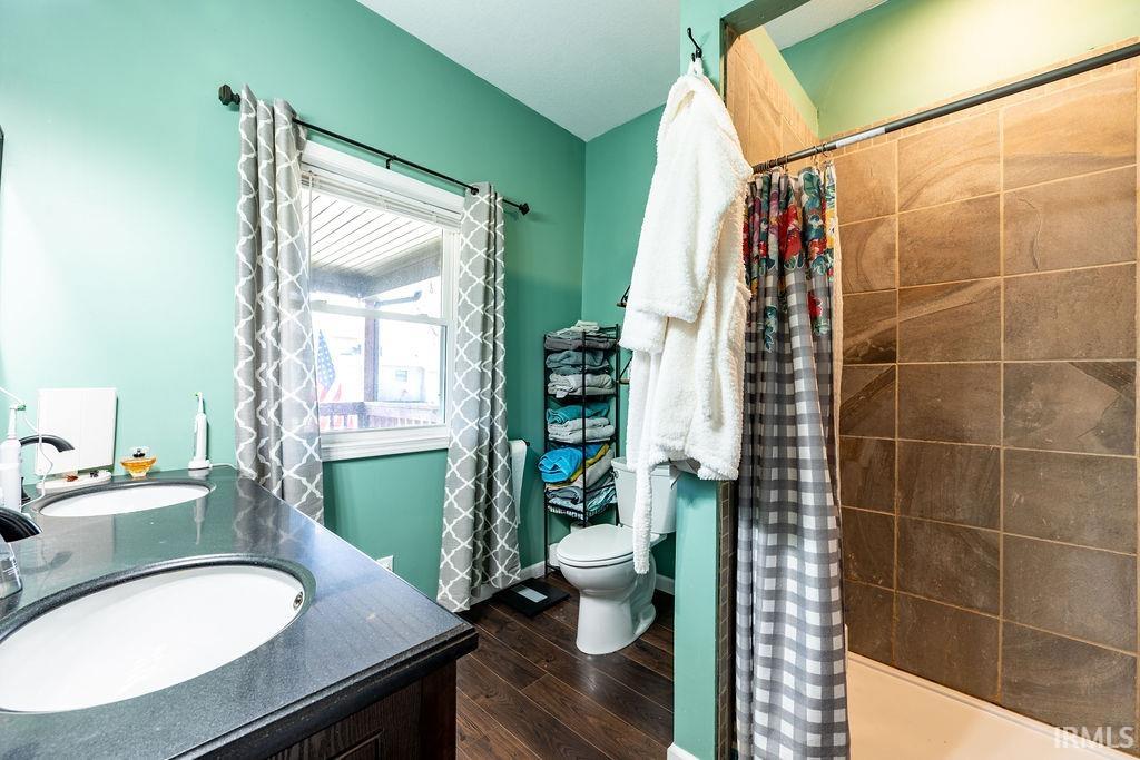 Bathroom with double vanity and dark wood finished floors