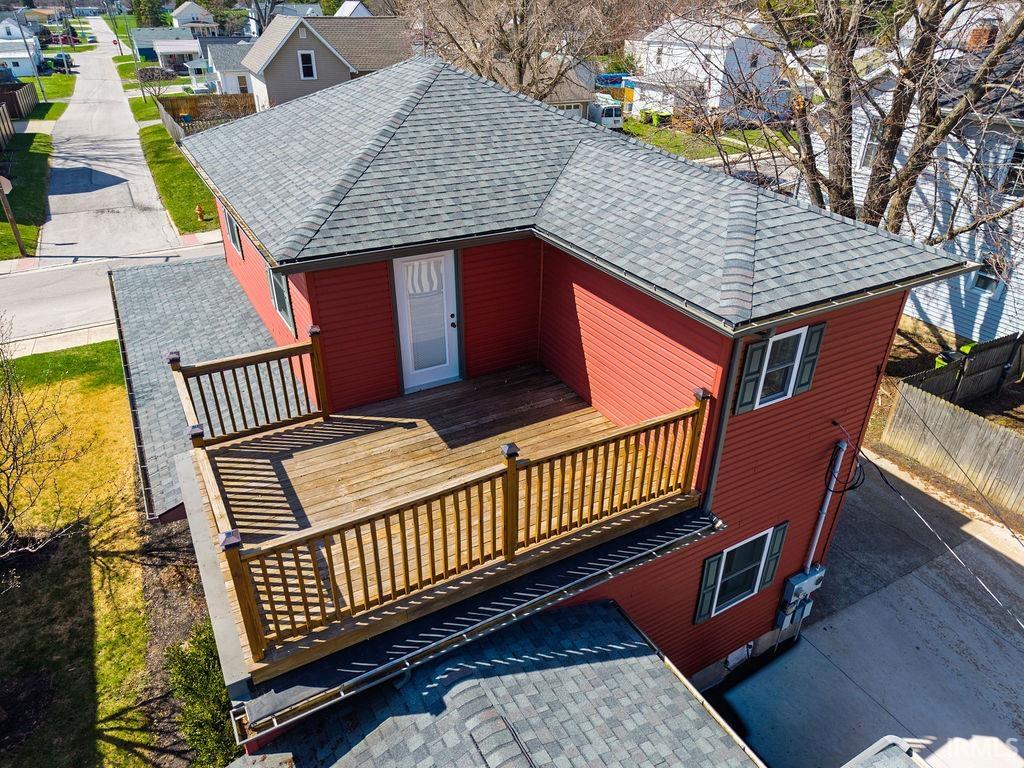 Rear view of house featuring a shingled roof and a residential view