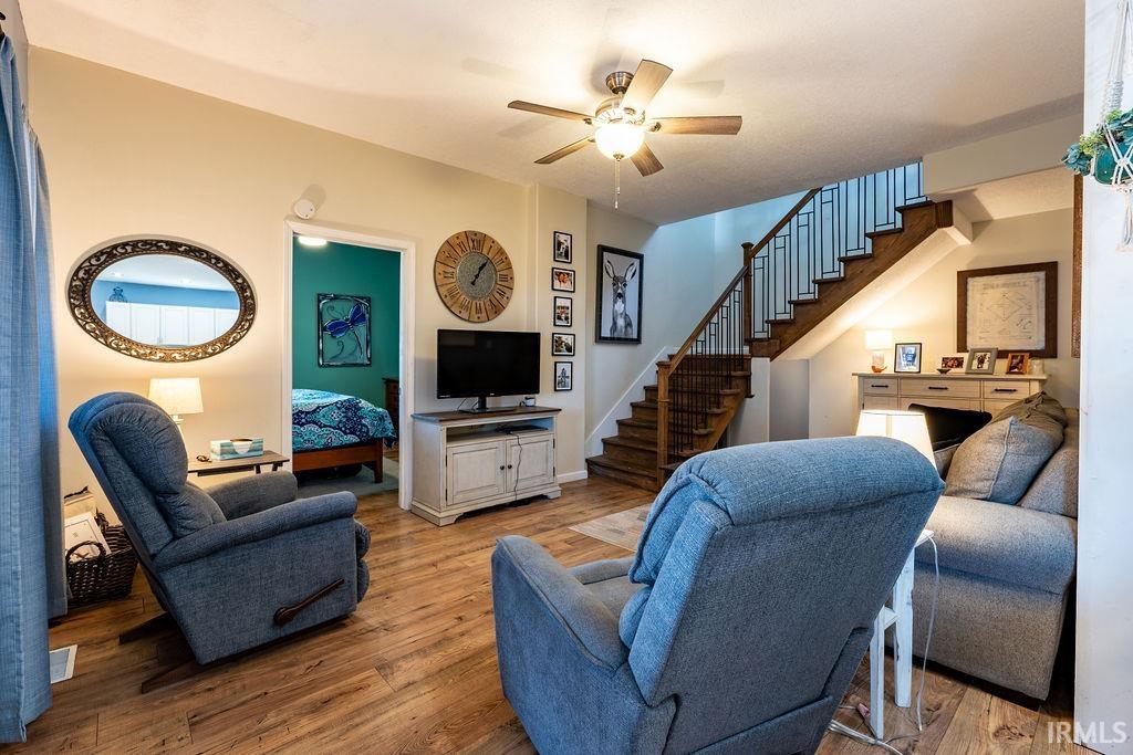 Living room with light wood-style floors and a ceiling fan