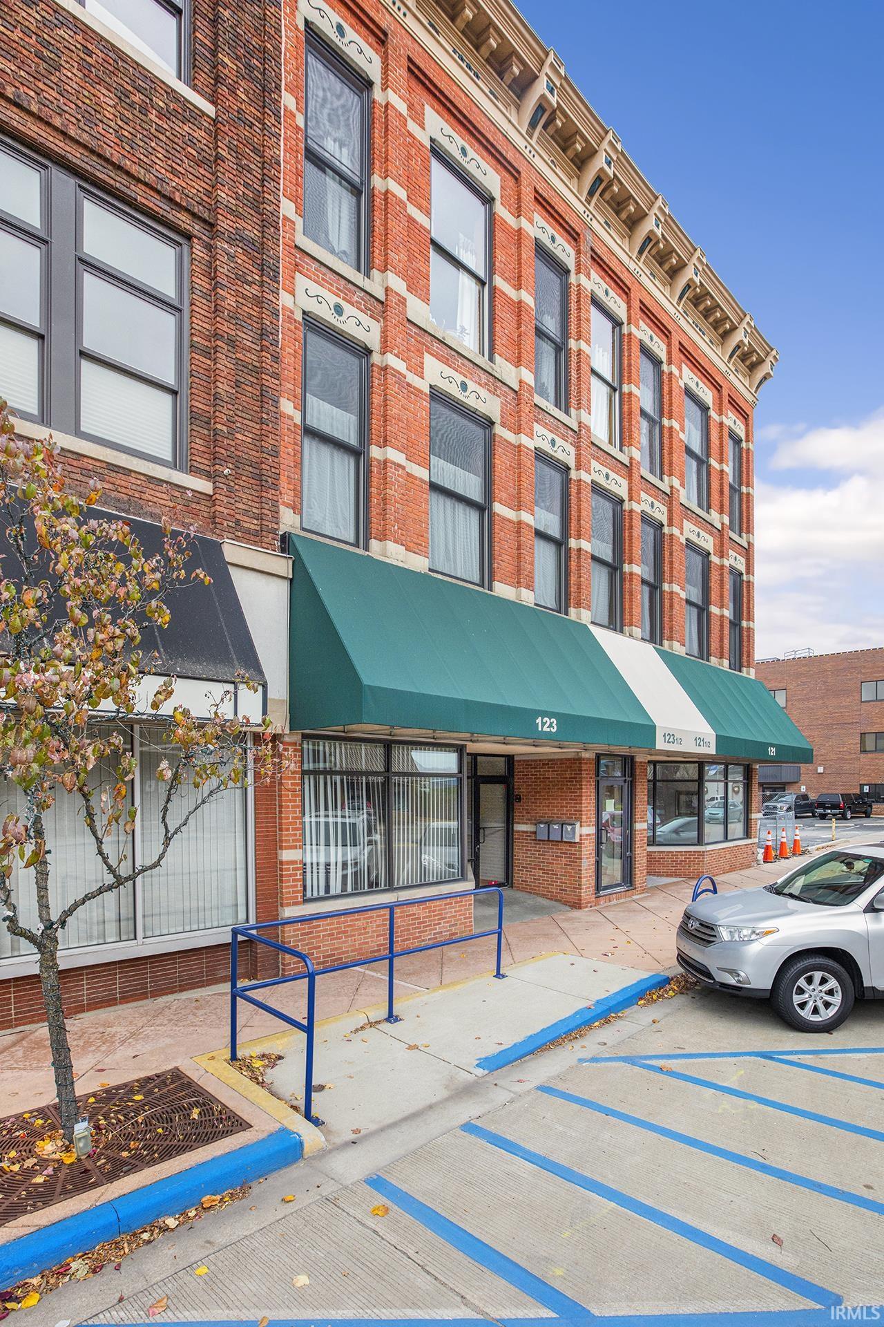 View of building exterior with uncovered parking