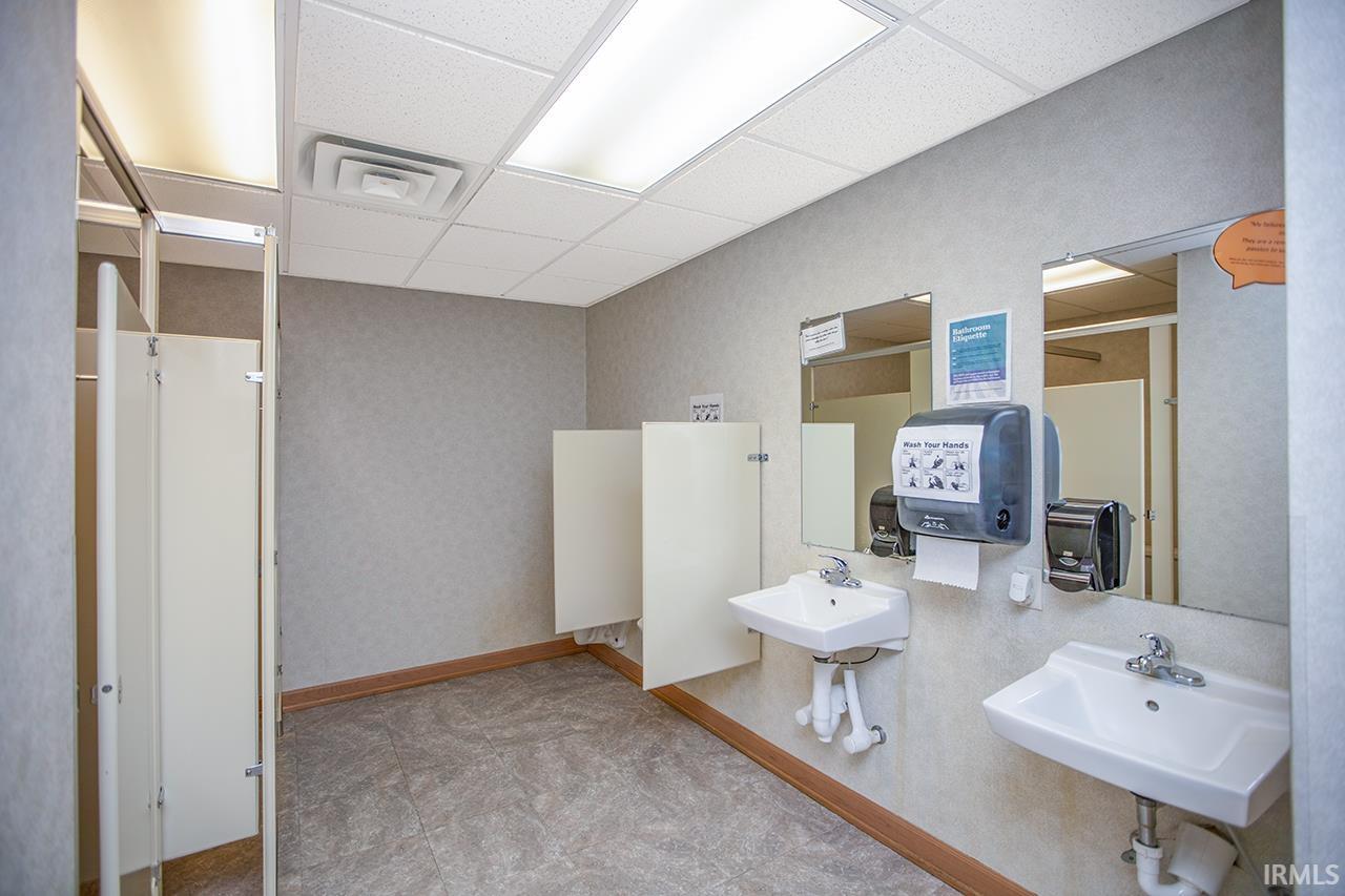 Bathroom with a drop ceiling and wallpapered walls