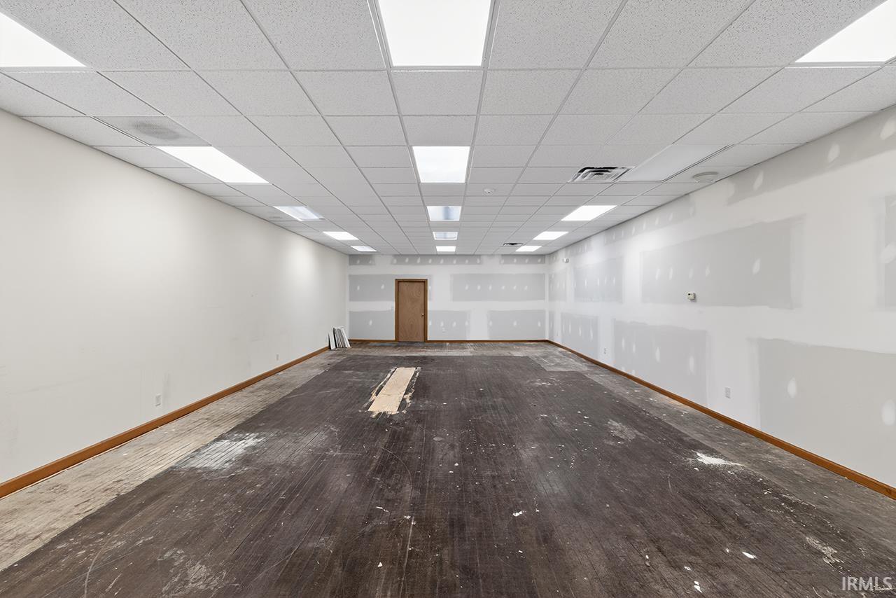 Empty room featuring baseboards and a paneled ceiling