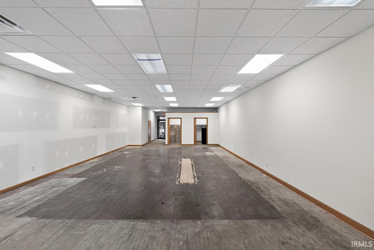 Empty room featuring a drop ceiling and wood finished floors