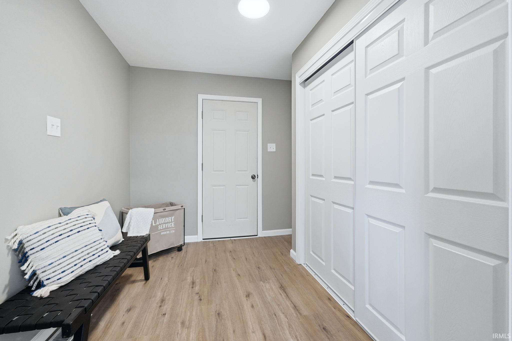 Living area featuring light wood-style floors and baseboards