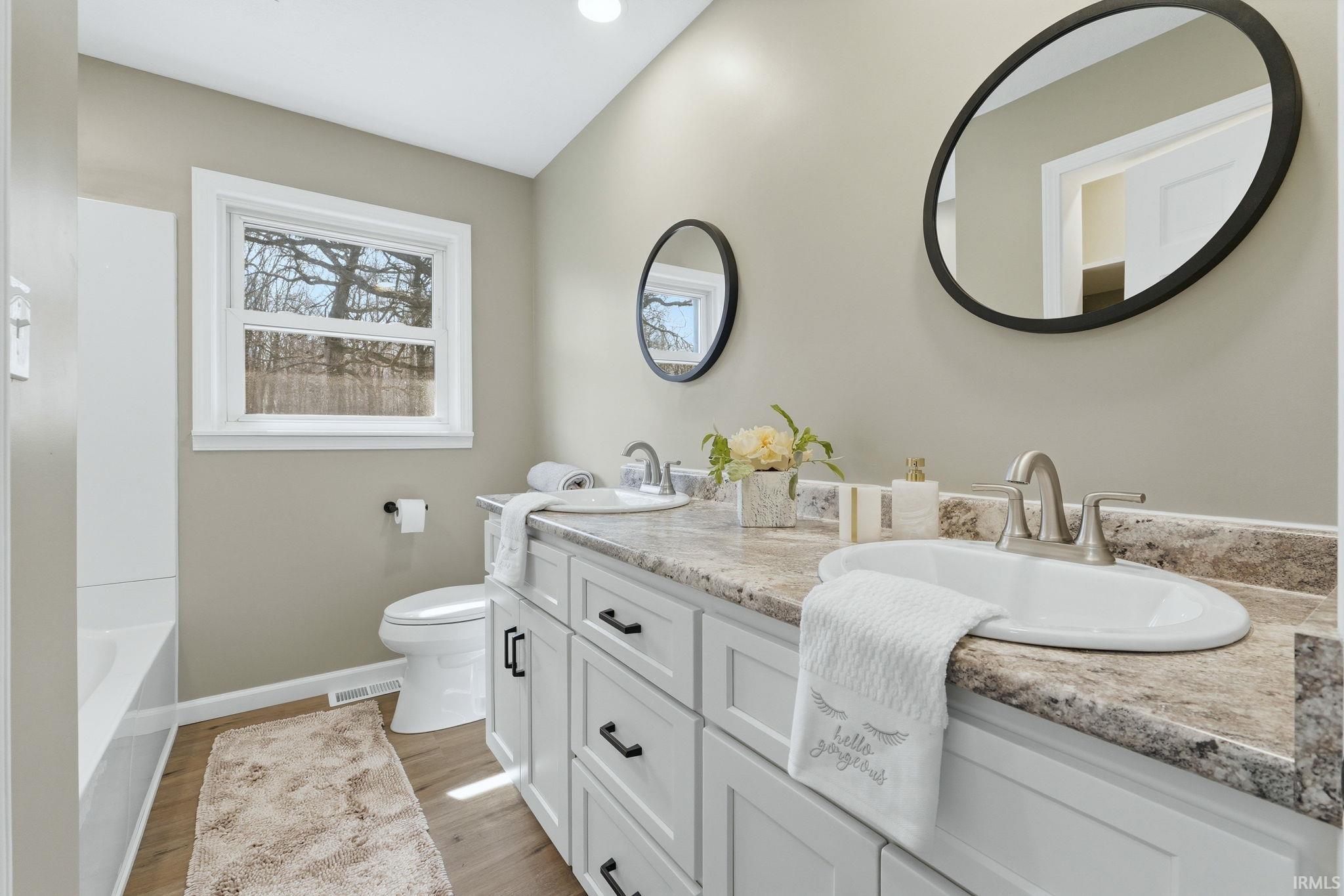 Bathroom featuring double vanity and light wood-type flooring