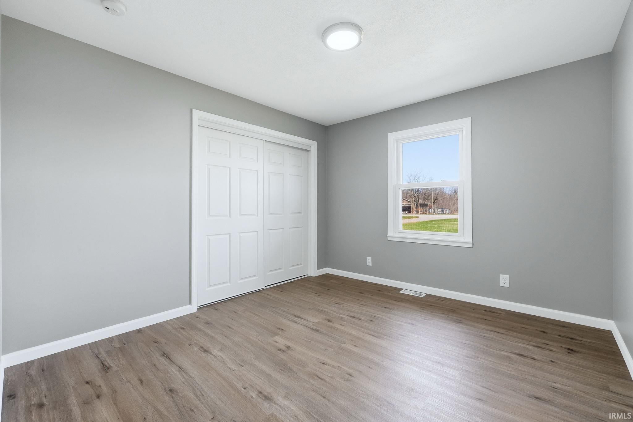 Unfurnished bedroom featuring light wood-style floors and a closet