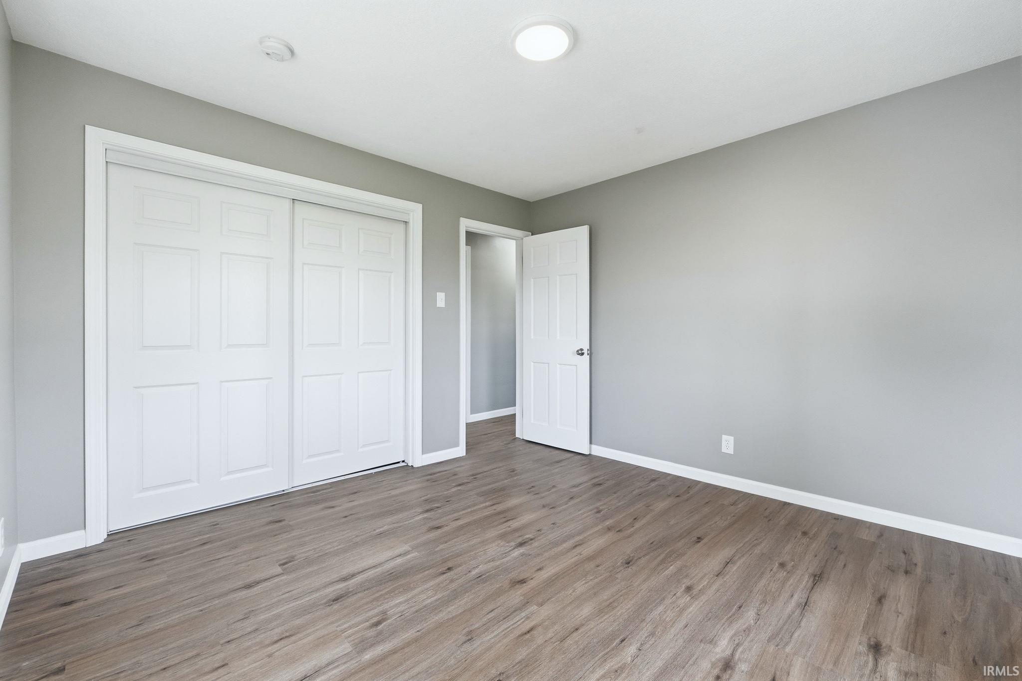 Unfurnished bedroom featuring wood finished floors and a closet