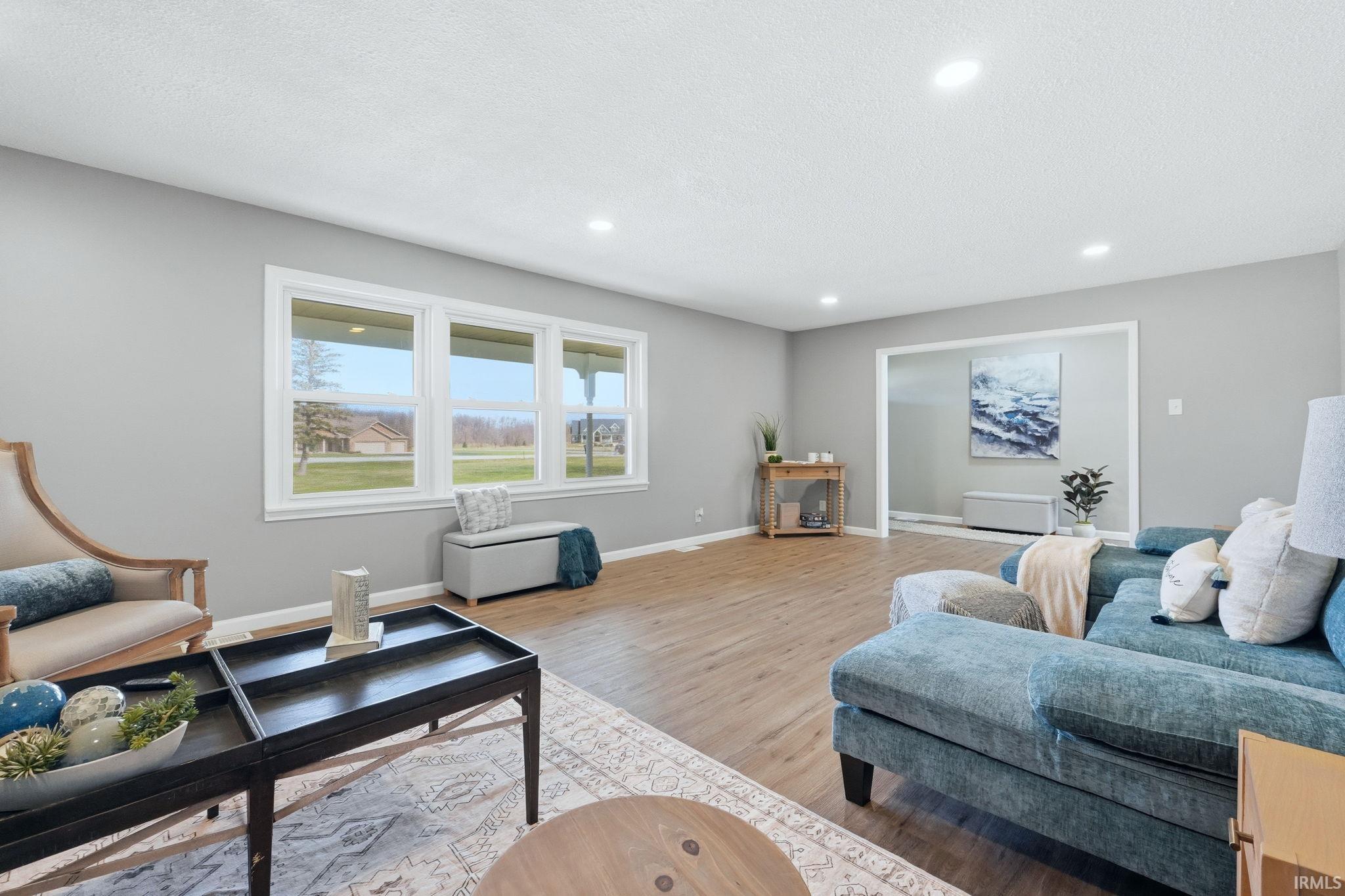 Living room with light wood-style floors, recessed lighting, and a textured ceiling