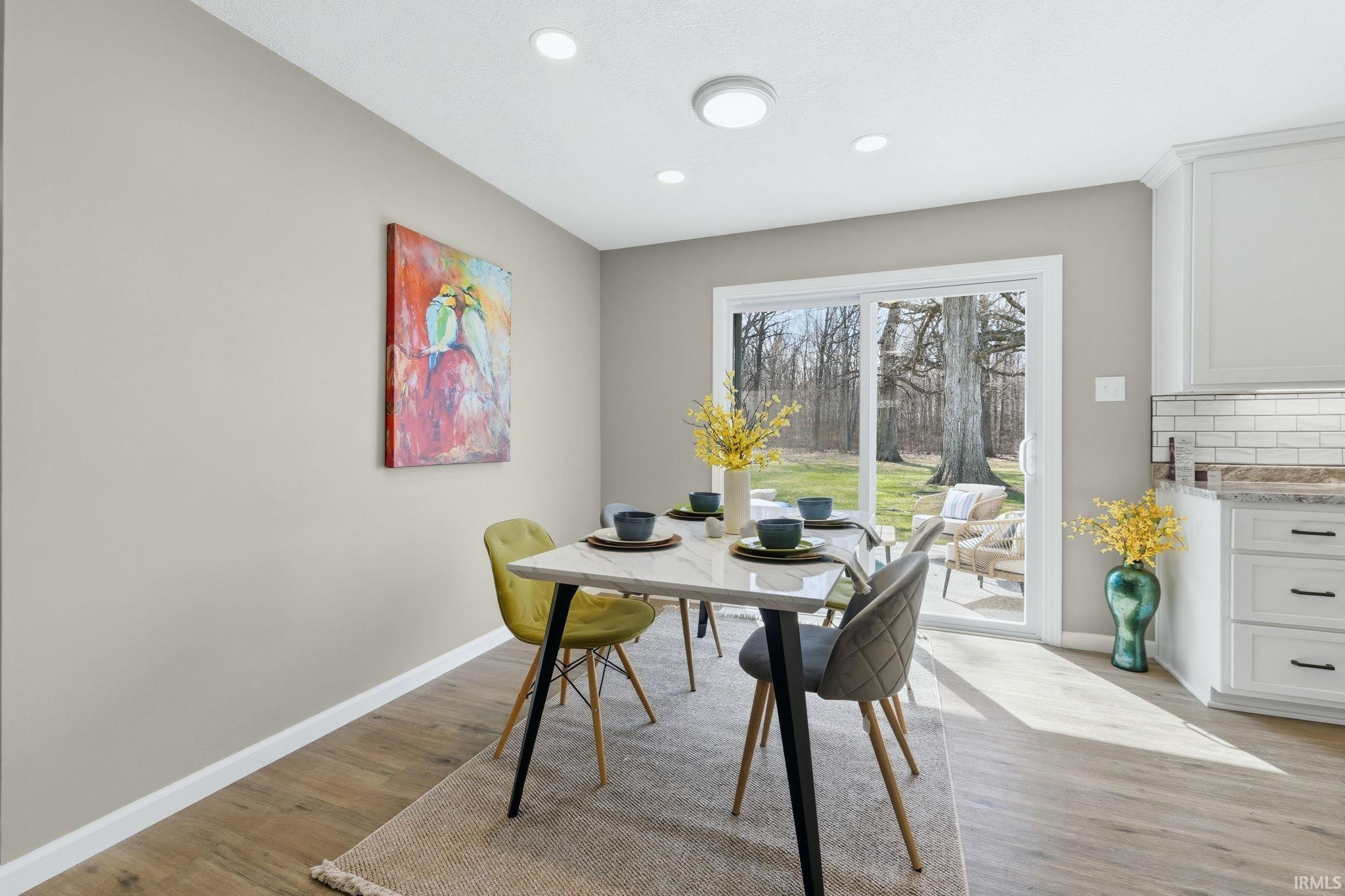 Dining area with light wood-type flooring and recessed lighting